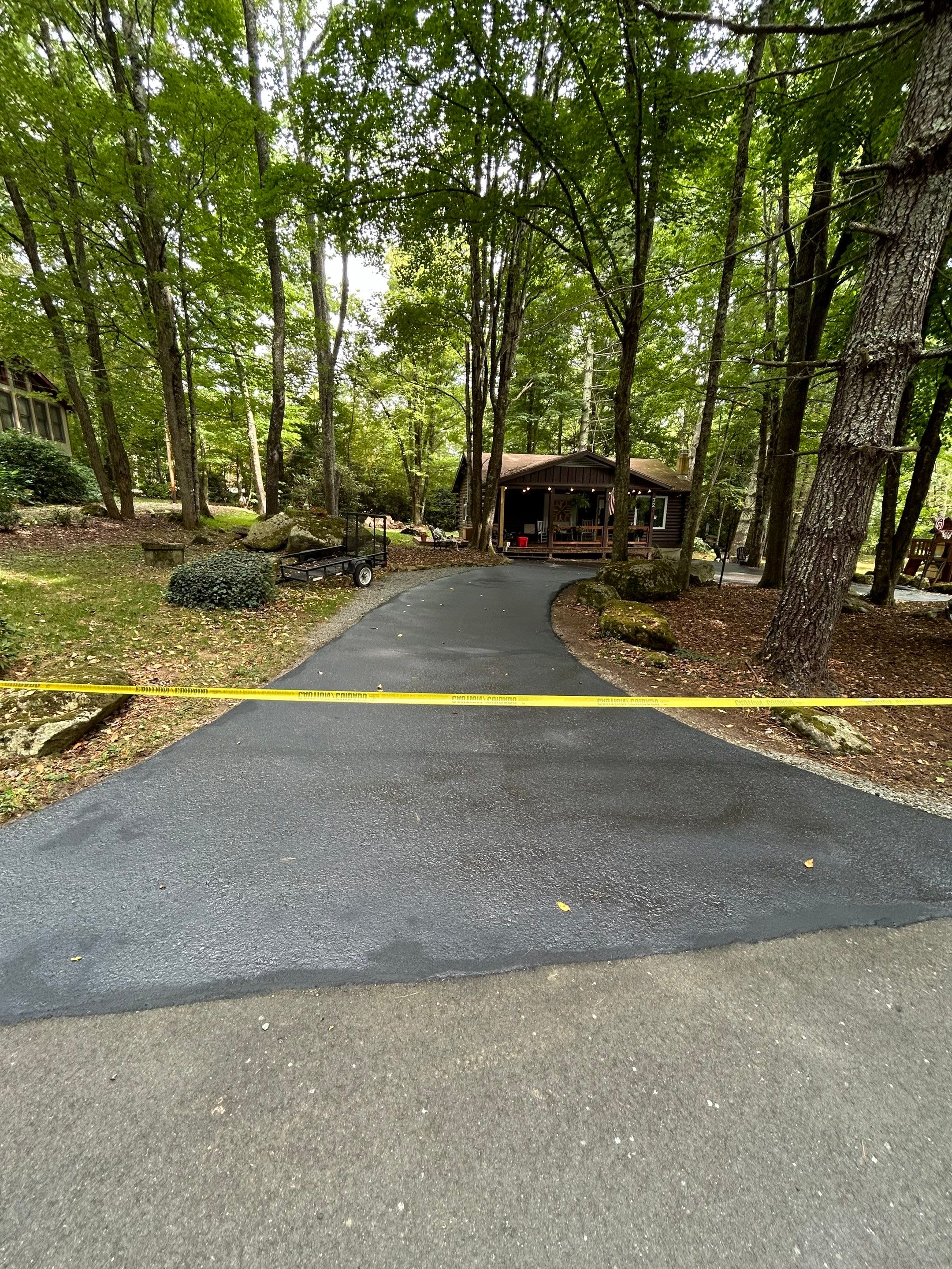 pressure washing is being performed on the asphalt driveway to remove dirt and grime for a clean appearance