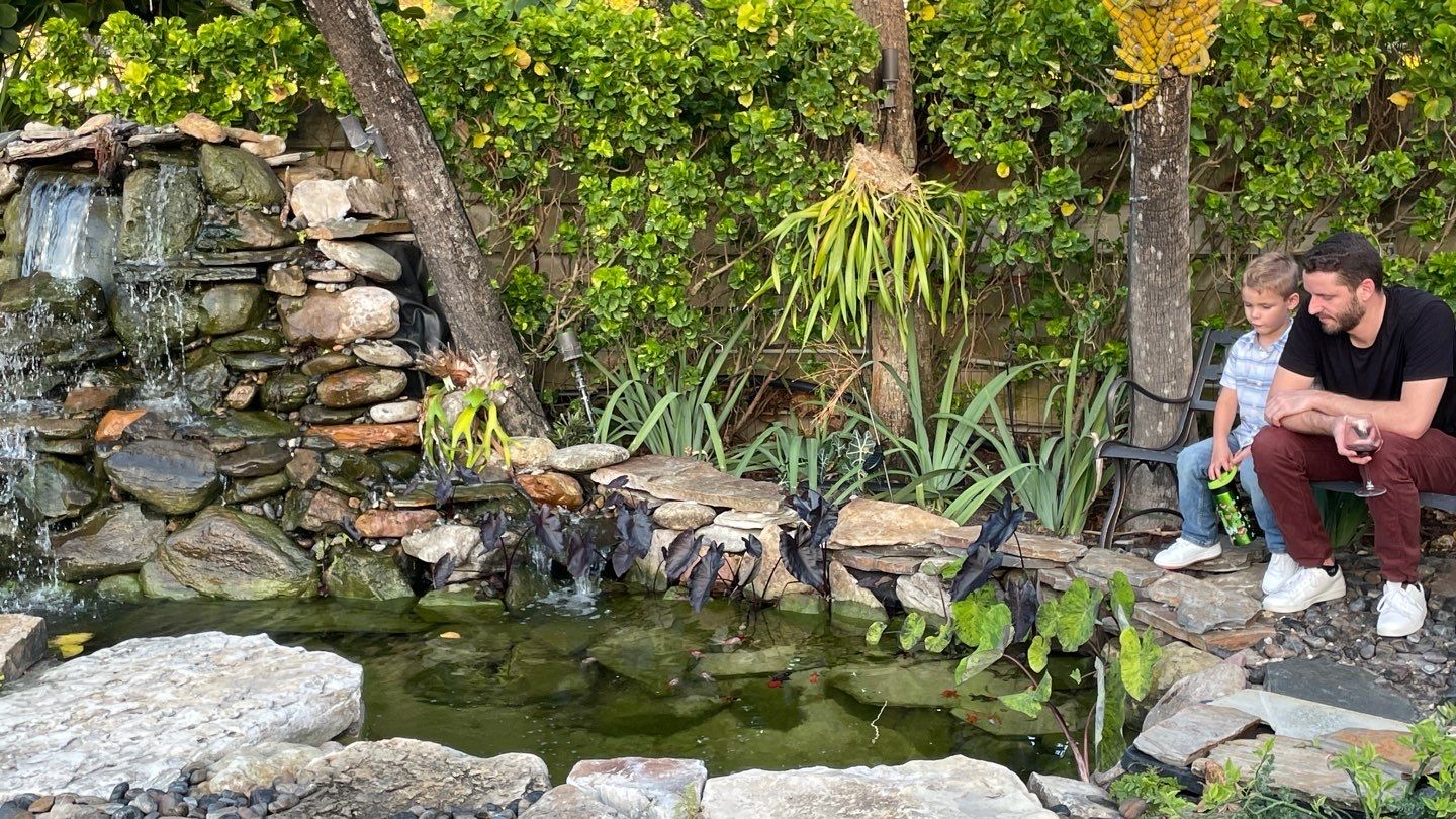 A Beautiful Relaxing Koi Pond with Waterfall in Pinecrest by Nature's Dream Landscape and Tree Service