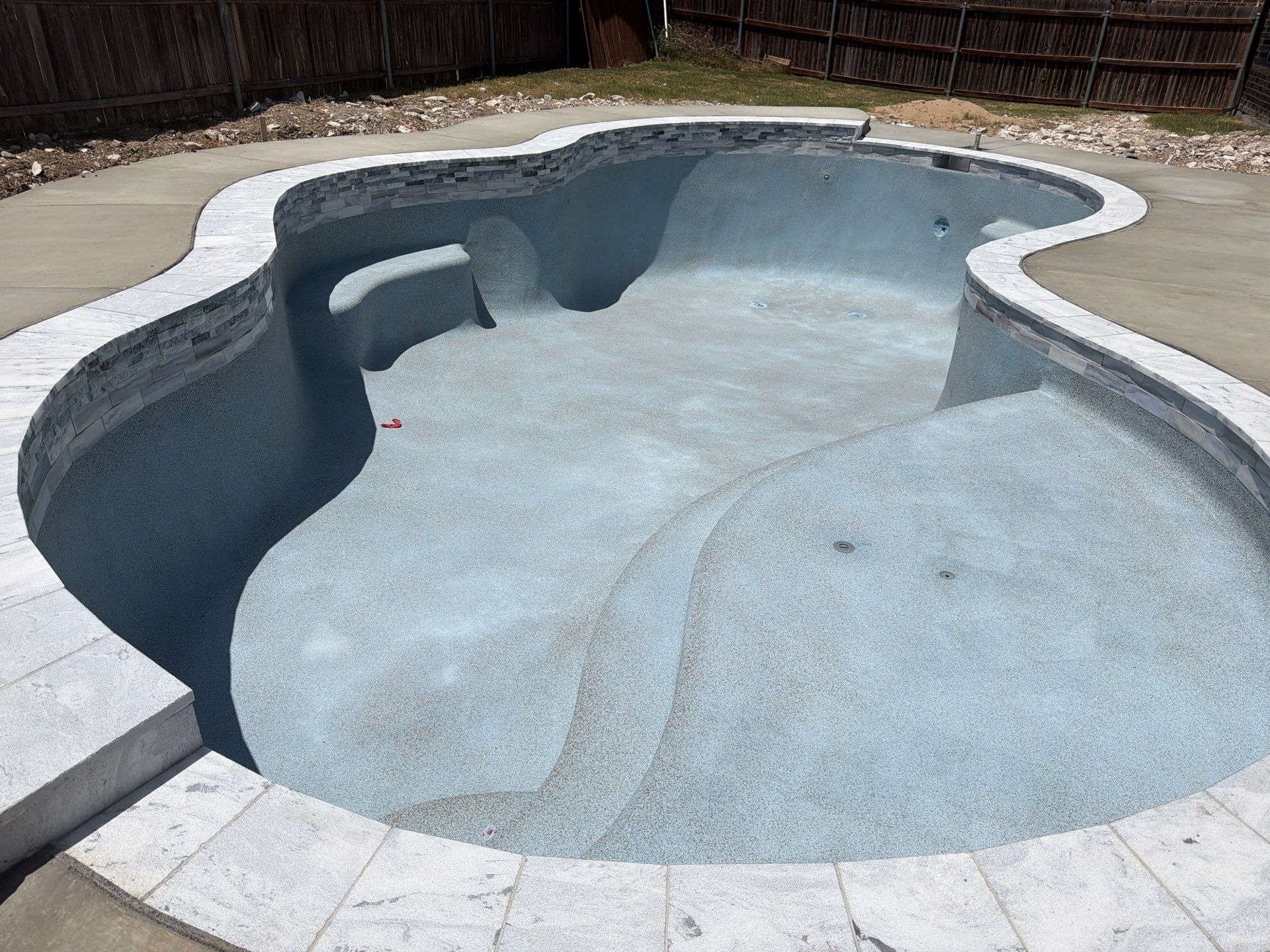 Freeform Pool with Tanning Ledge and Raised Stone Wall by Pinnacle Pools and Spas - DFW