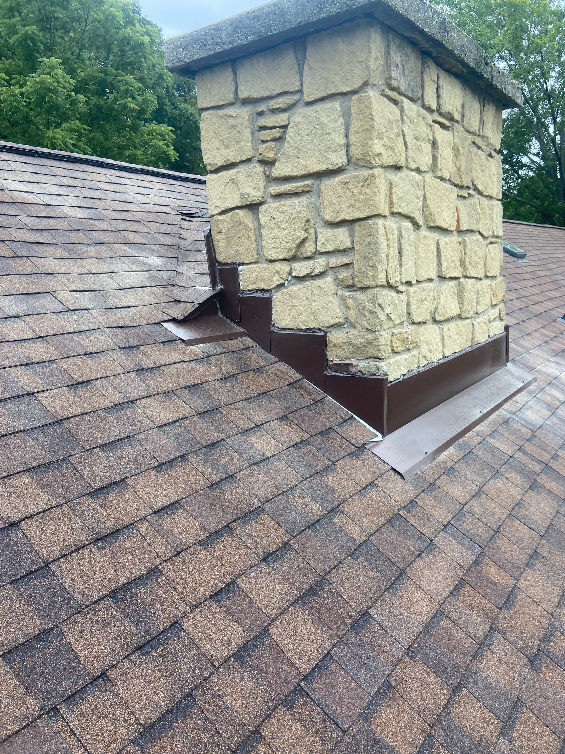 Shingle Roofing with Velux Skylight replacement and stone chimney flashing  by Secure Construction Company Inc