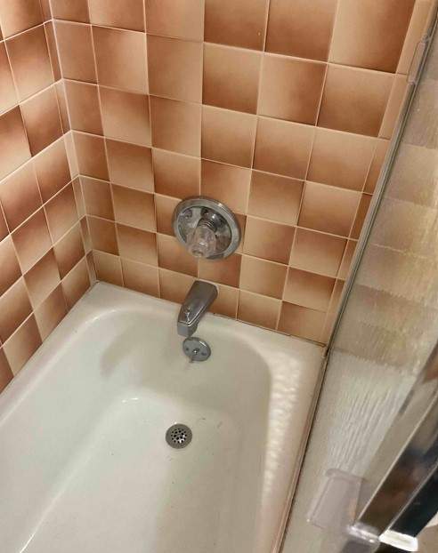 Bathtub, door, toilet, flooring, and countertop by The Shower Company