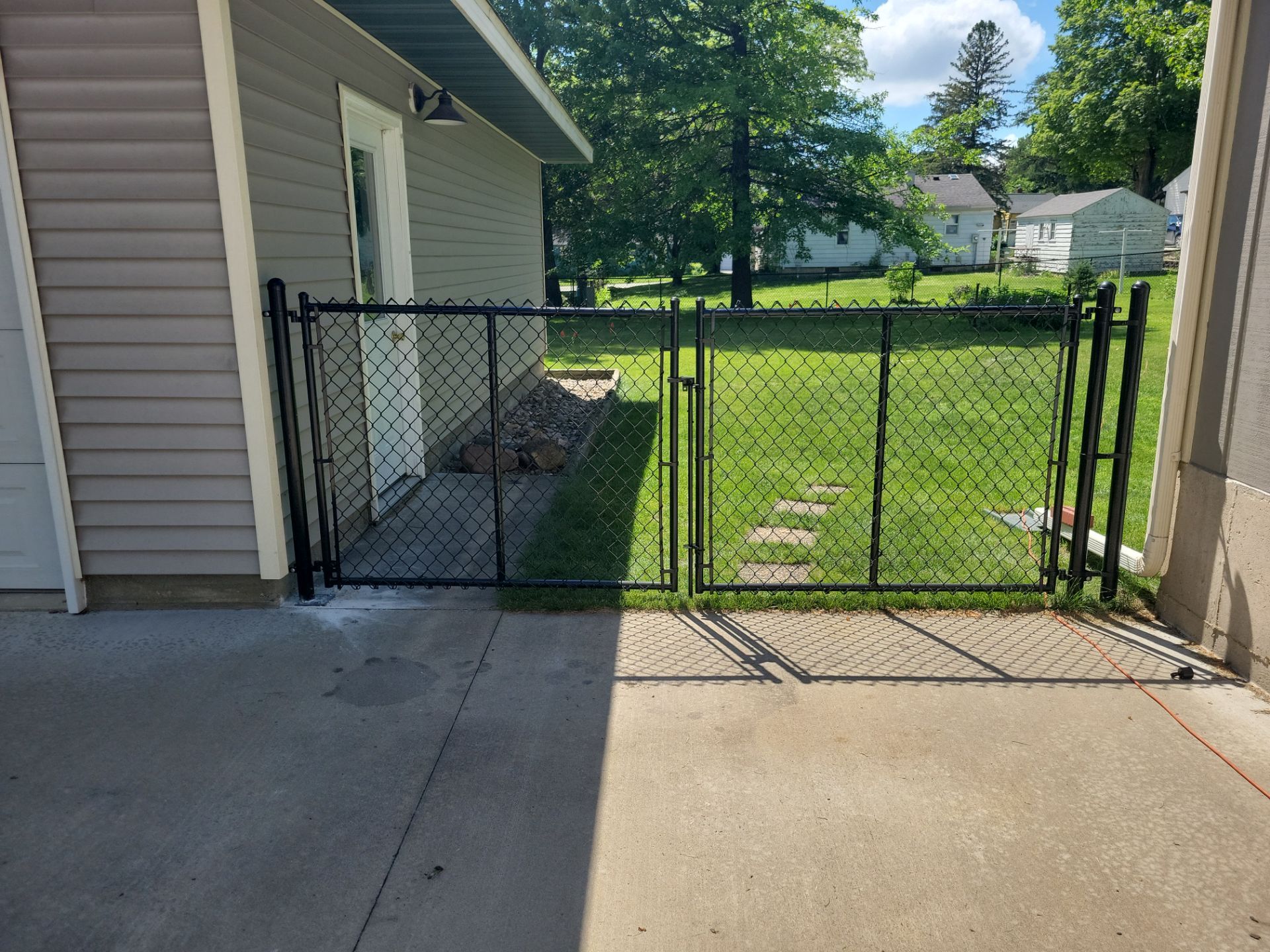 Black Chain Link Perimeter Fence and Driveway Gate in Waverly by Perfect Picket Fence and Stain