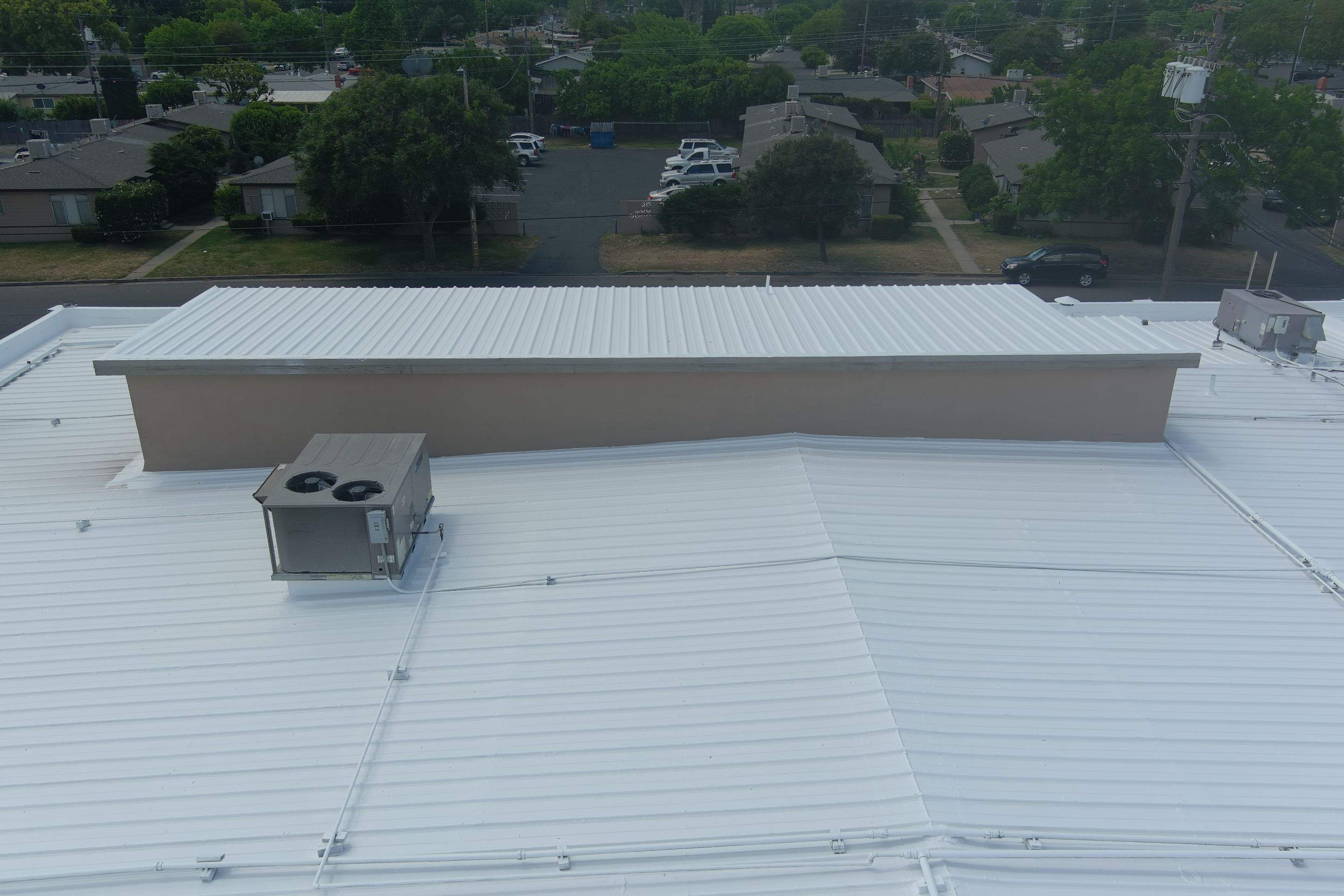 Metal roof restoration on commercial roof using Conklin Benchmark/ PUMA XL acrylic coatings over metal and foam by Straight Edge Roofing Inc