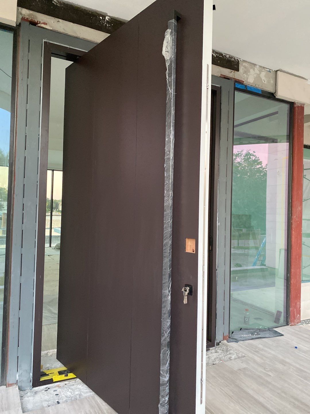 Custom Material Pivot Door installation by Impact Precious Wood Inc.