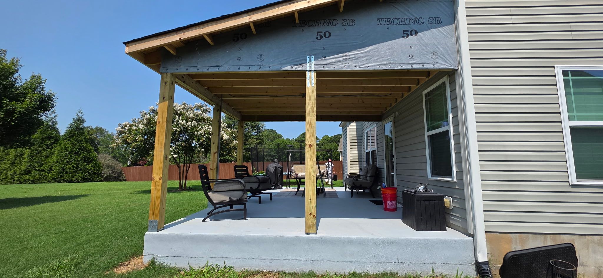 Covered Patio Roof Construction with Architectural Shingles in Garner by The Remodeling Company