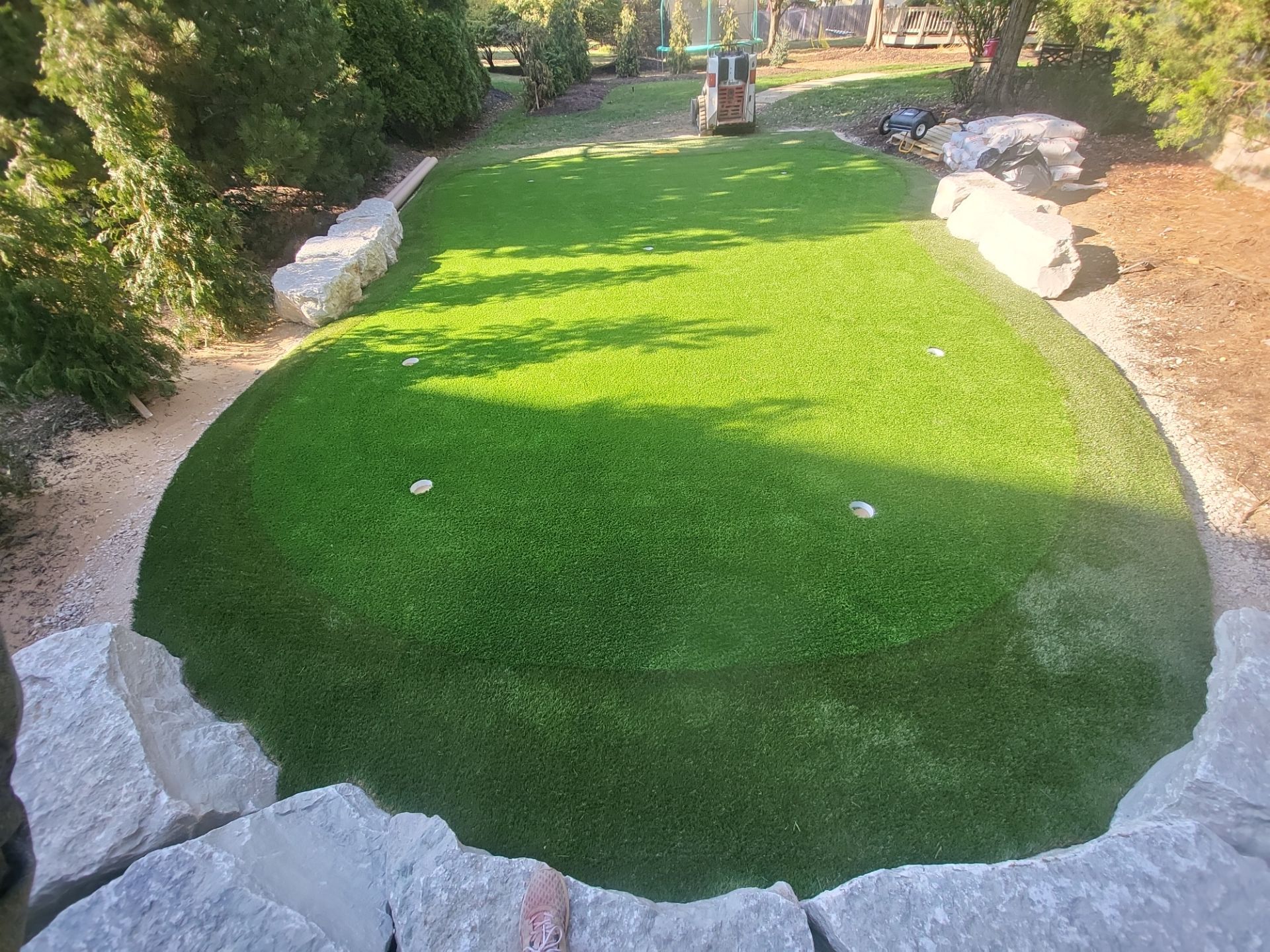 Custom Backyard Putting Green around Landscape Boulders in Hilliard by Southwest Greens Midwest