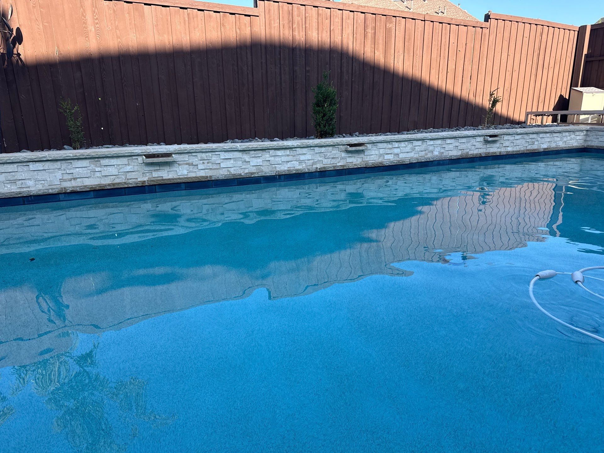 Geometric Pool with Raised Stone Waterfall Wall by Pinnacle Pools and Spas - DFW
