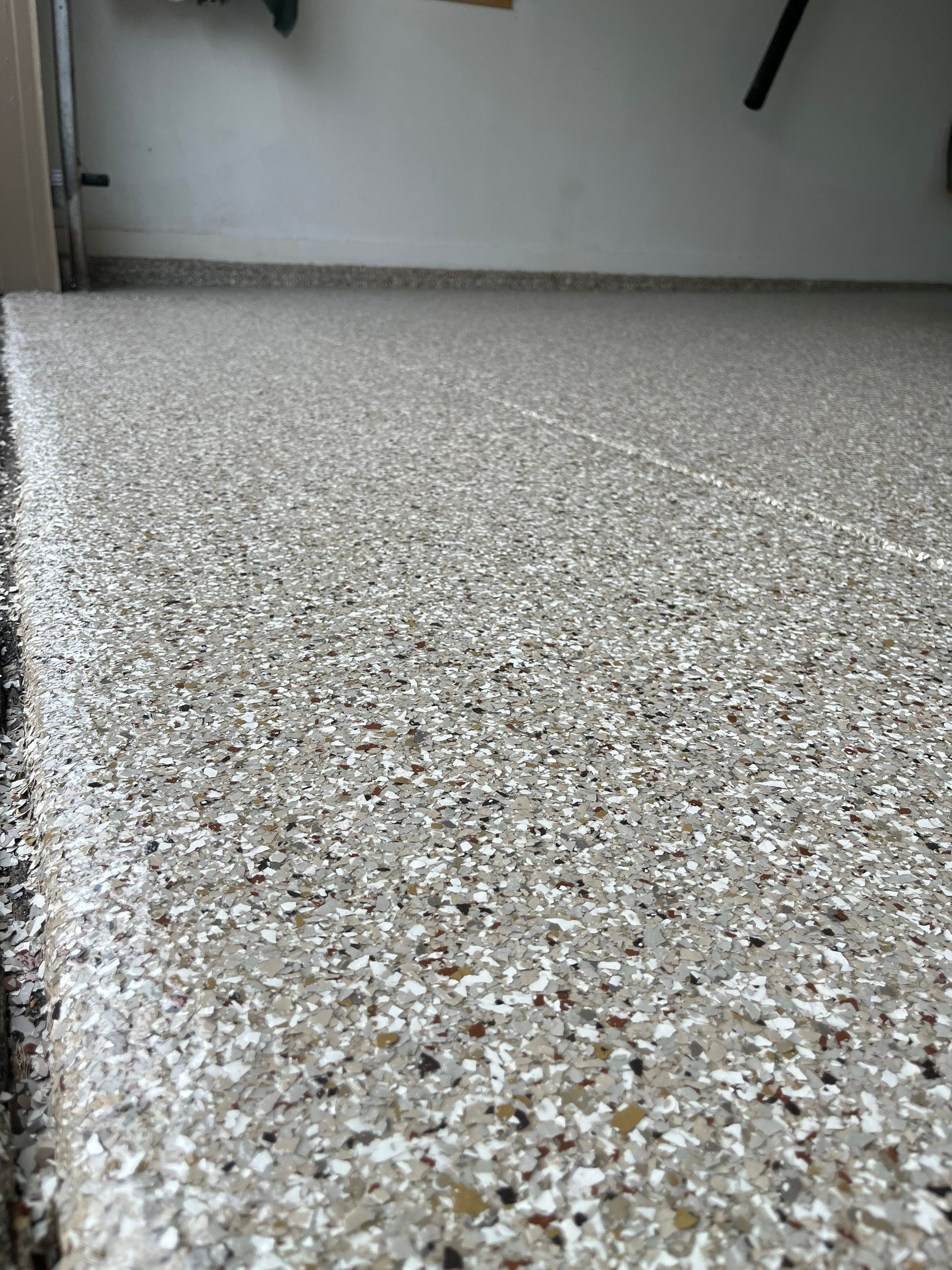 West Des Moines Garage and Patio Floor Coating using Pebble Beach Flakes by Revival Concrete Coatings
