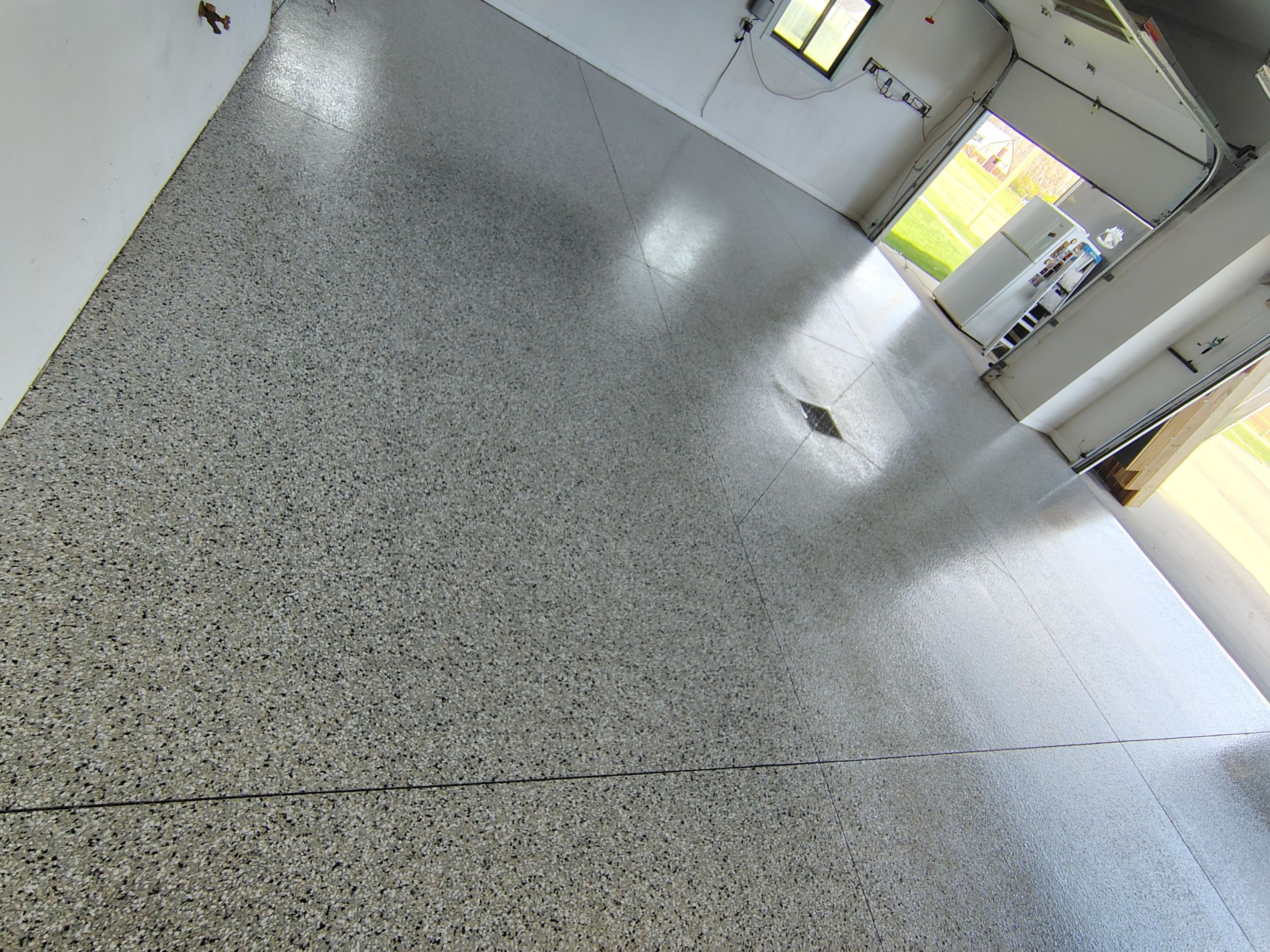 Speckled Polyaspartic Garage Floor Coating Installation in Dell Rapids by Select Painting, Coatings & Garage Cabinets