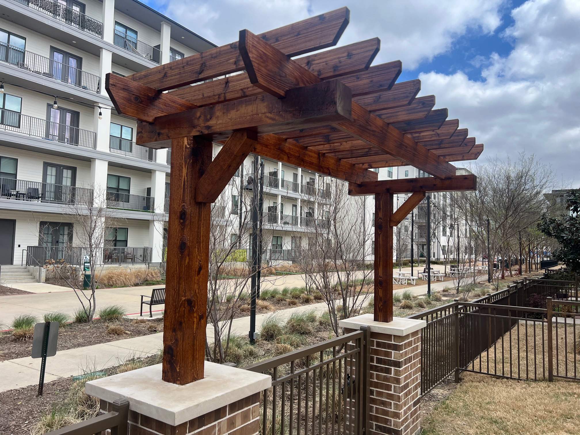 Arbor with Wrought Iron Fencing by 3:16 Roofing and Construction