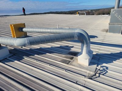 Wide view of a metal roof with ventilation ducting.