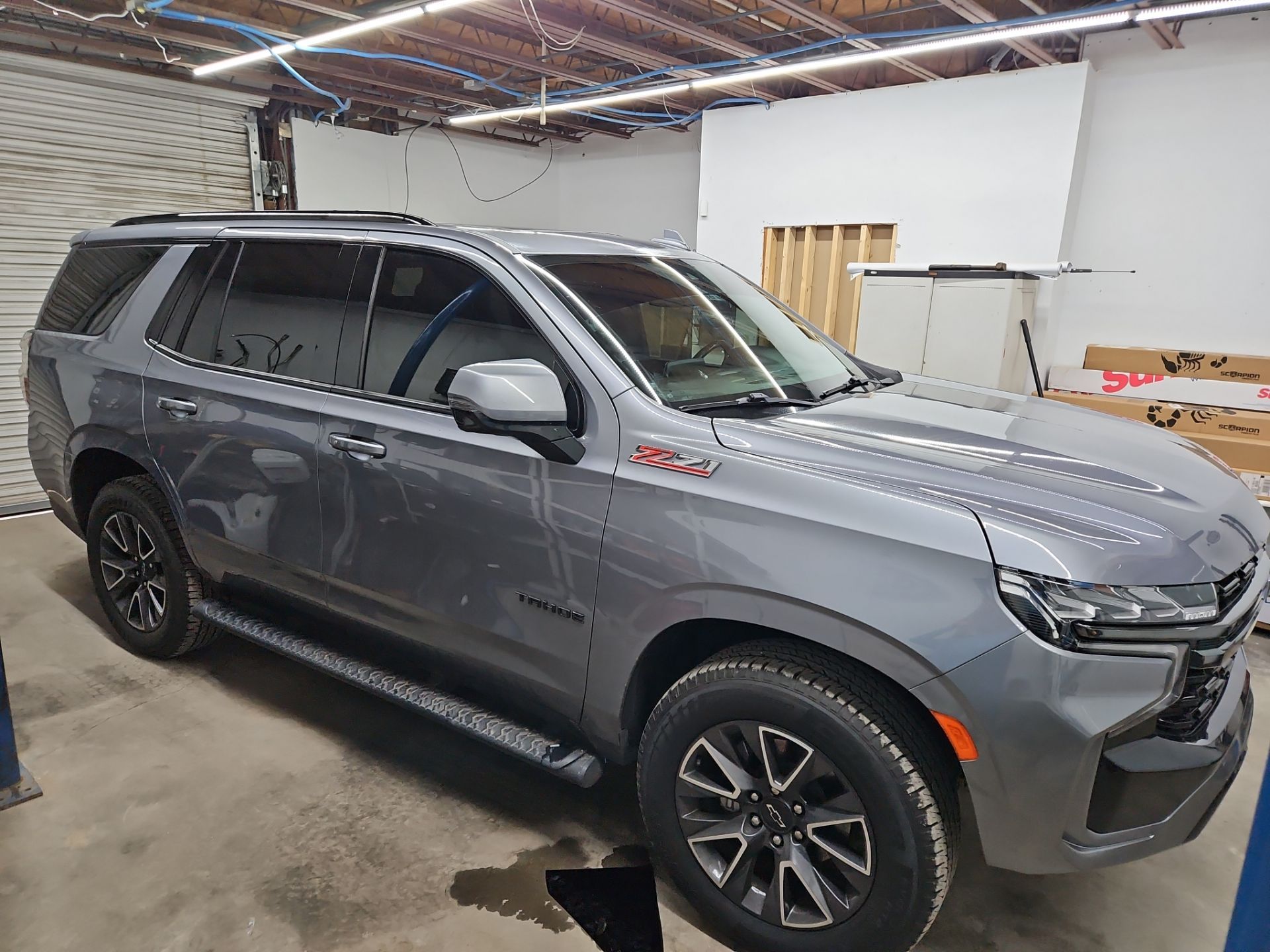 the image shows a grey suv that is having window tinting applied the service includes installation of tinted film on the windows which helps reduce glare and heat inside the vehicle it also enhances privacy and protects the interior from UV damage the car looks new and is likely being treated to improve its aesthetic and functional qualities the tinting process is done in a clean and controlled environment to ensure a professional finish