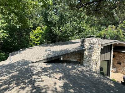 Driftwood Oakridge Roofing Around an Austin Stone Chimney