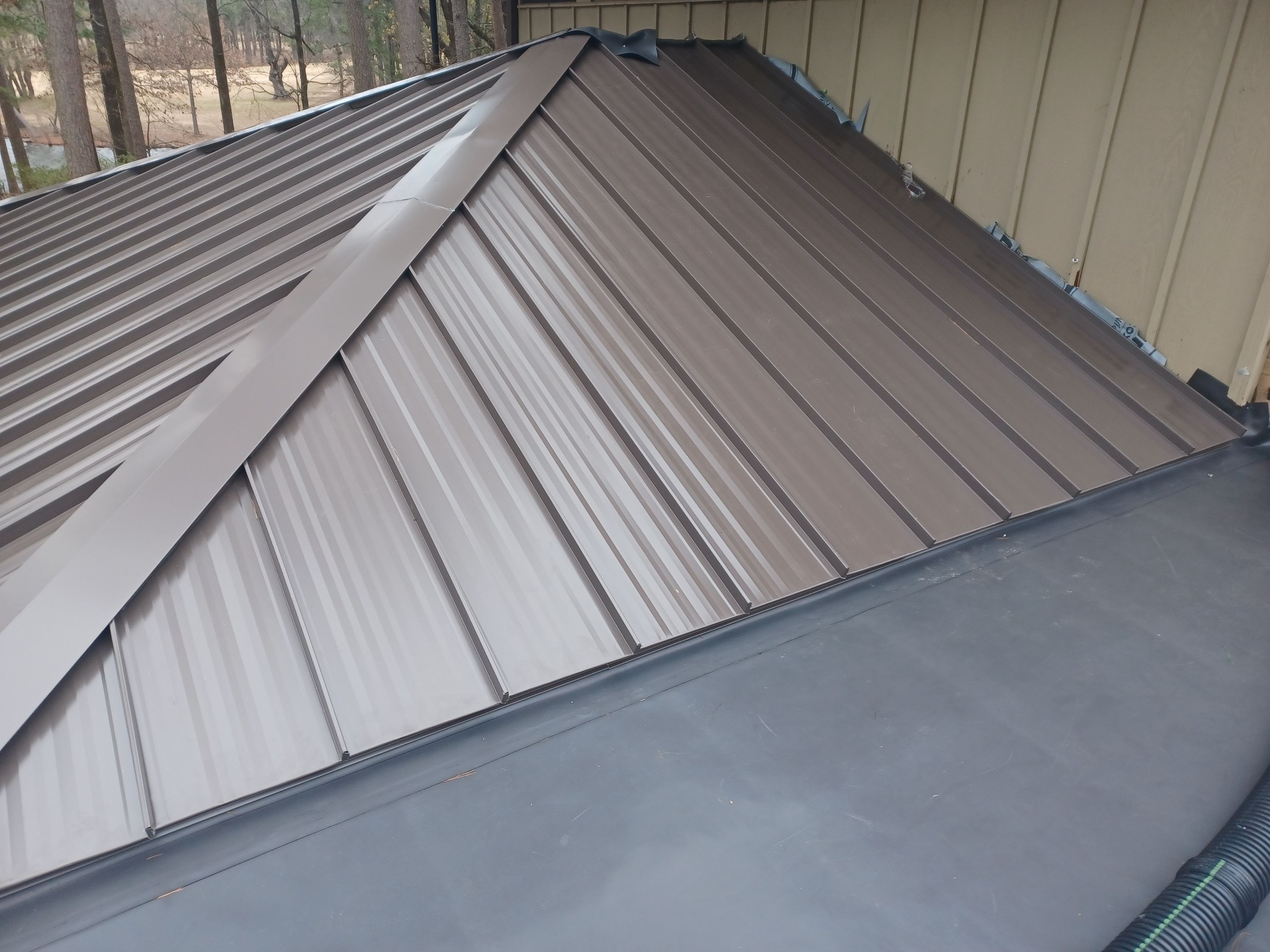 Residential Roofing Installation using PVC membrane and 24 gauge Standing Seam Metal by Hostetler Roofing