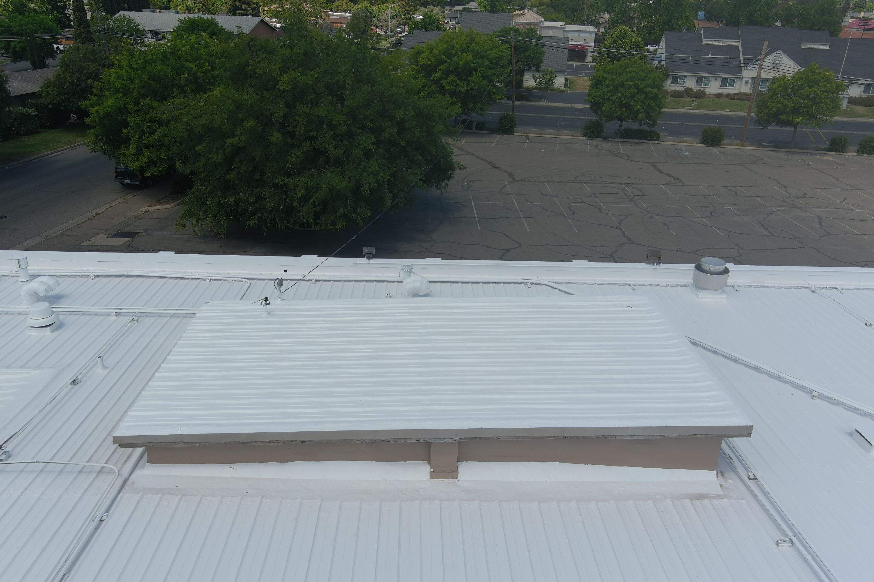 Metal roof restoration on commercial roof using Conklin Benchmark/ PUMA XL acrylic coatings over metal and foam by Straight Edge Roofing Inc