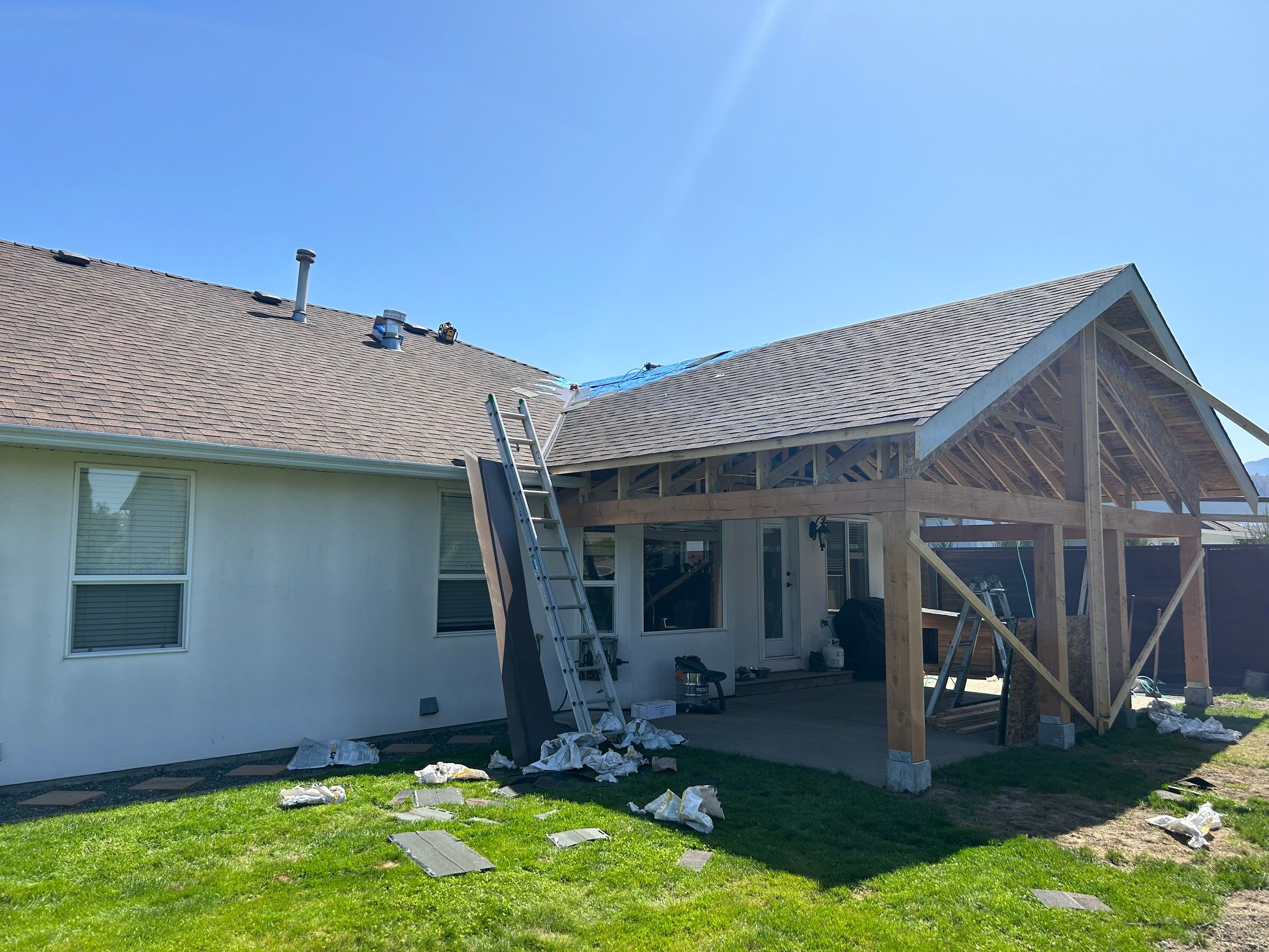 Residential patio roof extension with IKO Dual Brown shingles by Top Notch Roofing Inc