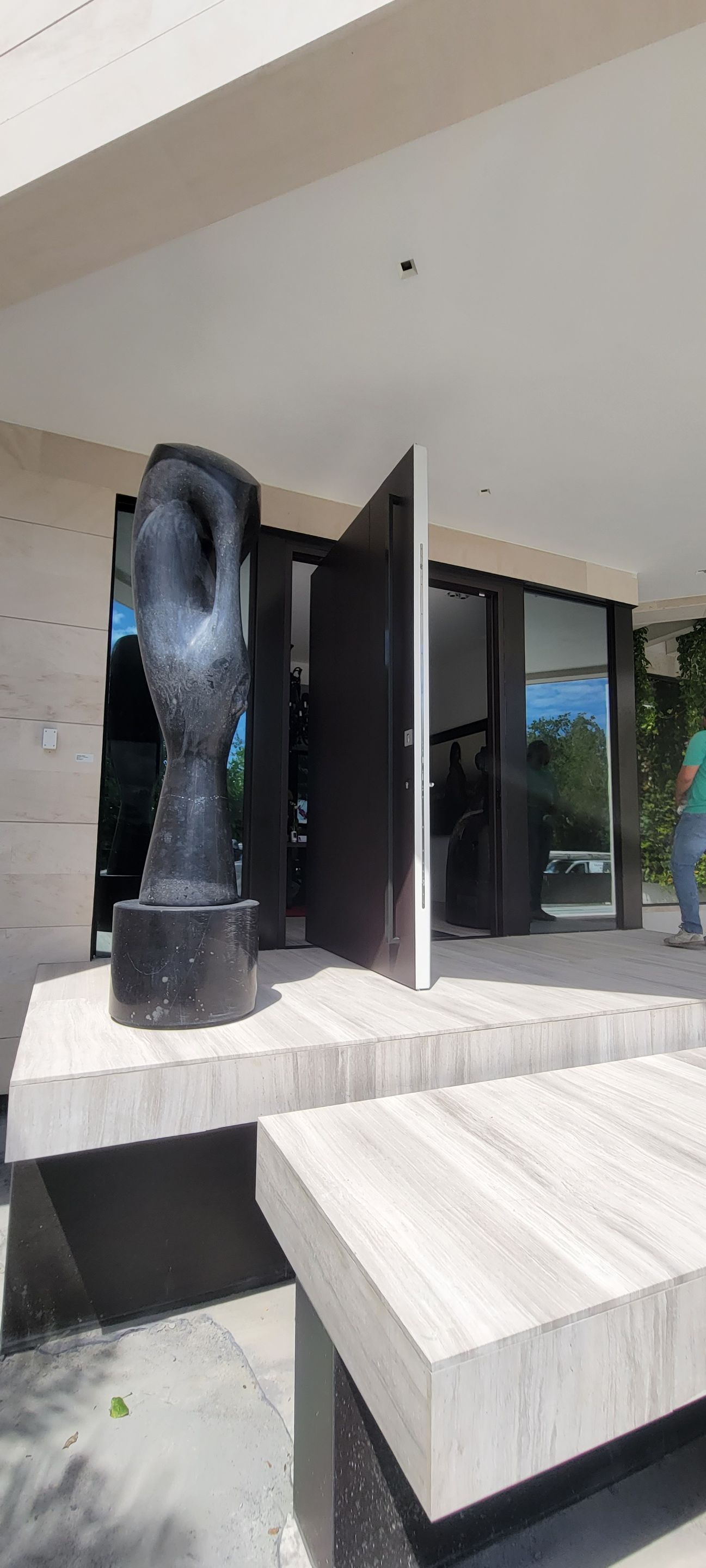 Custom Material Pivot Door installation by Impact Precious Wood Inc.