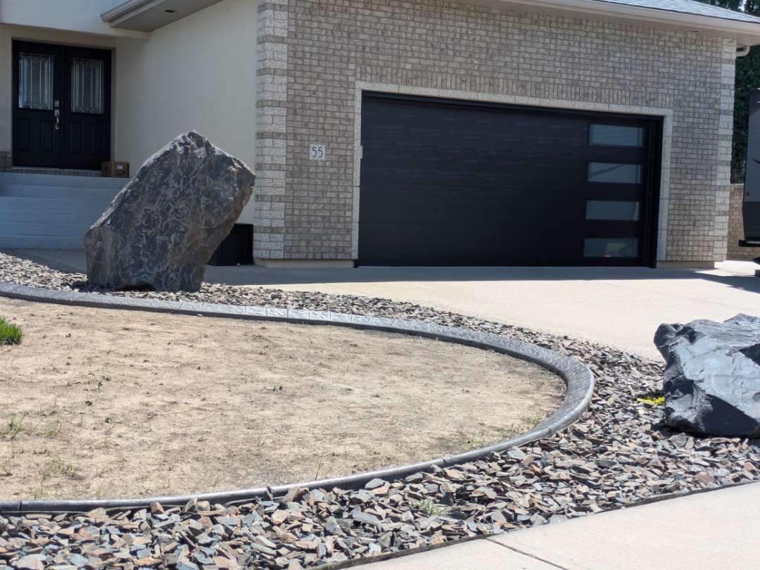 Custom Stamped Concrete Curbing and Decorative Rock Bed Installation