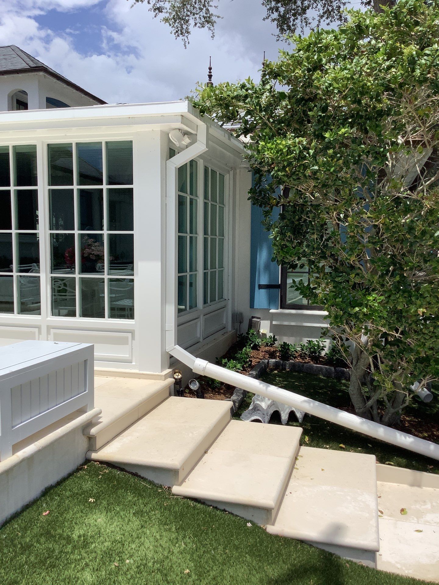 Seamless aluminum gutter installation in Sarasota, FL using 3x4 elbow downspouts combined with round downspouts by Gutter Professors