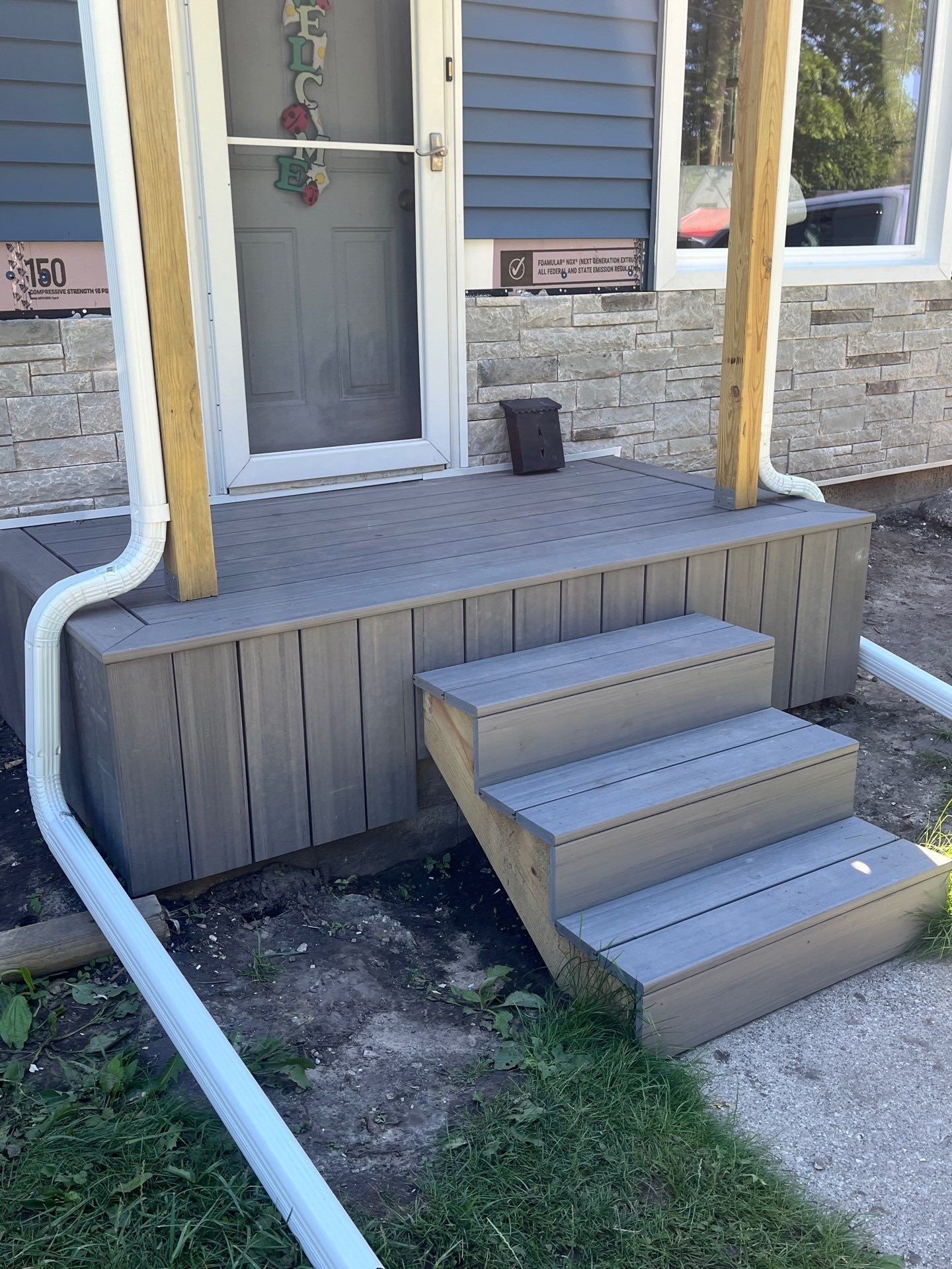 Blue Vinyl Siding and Versetta Stone Exterior Remodel in Bay City by Great Lakes Home Design LLC