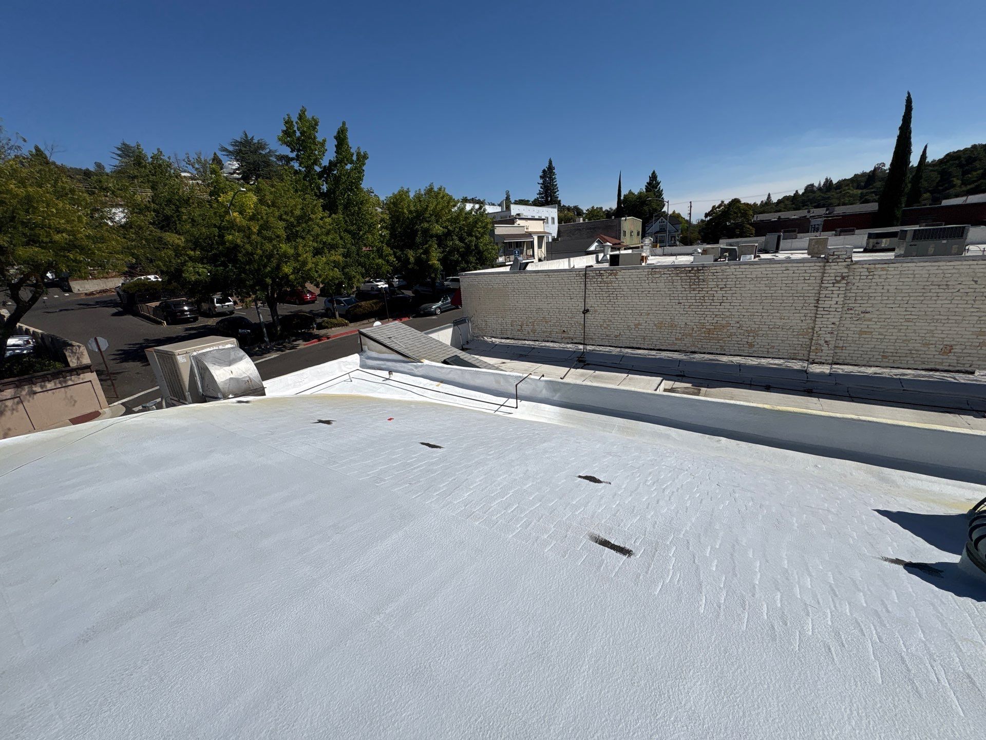 Foam and coatings on commercial roof by Straight Edge Roofing Inc