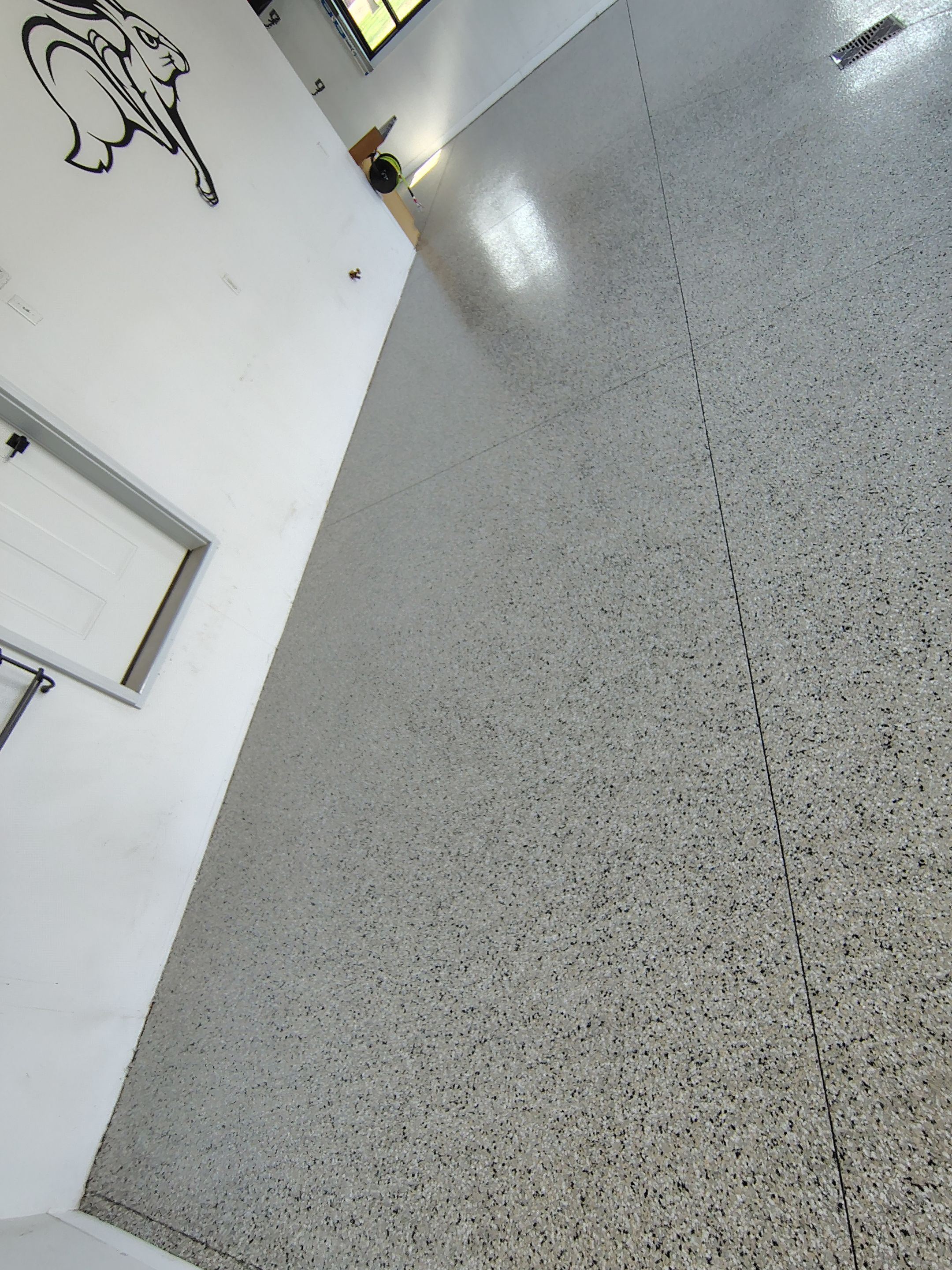 Speckled Polyaspartic Garage Floor Coating Installation in Dell Rapids by Select Painting, Coatings & Garage Cabinets