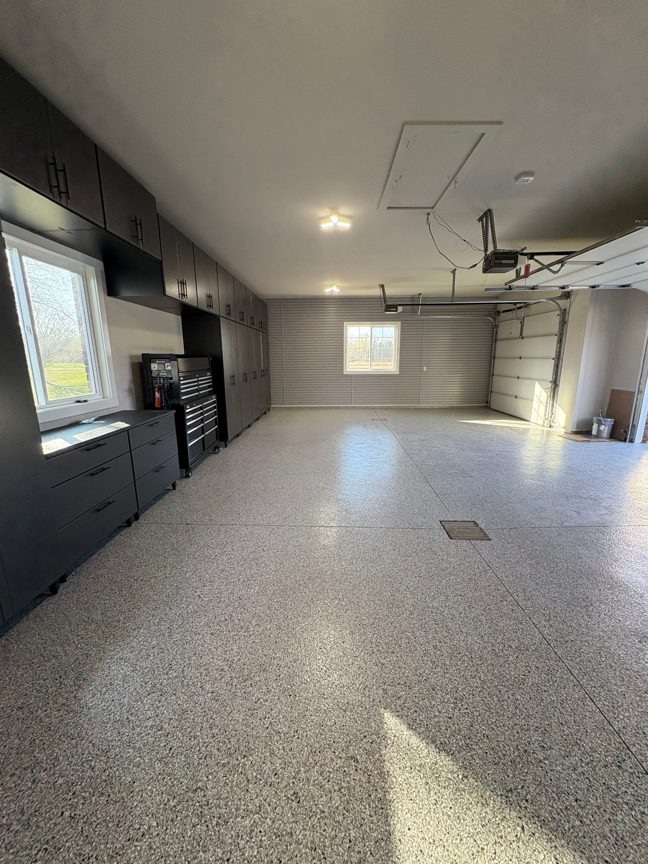 Yankton Garage Transformation with Dark Storage Cabinetry and Epoxy Flooring by Select Painting, Coatings & Garage Cabinets