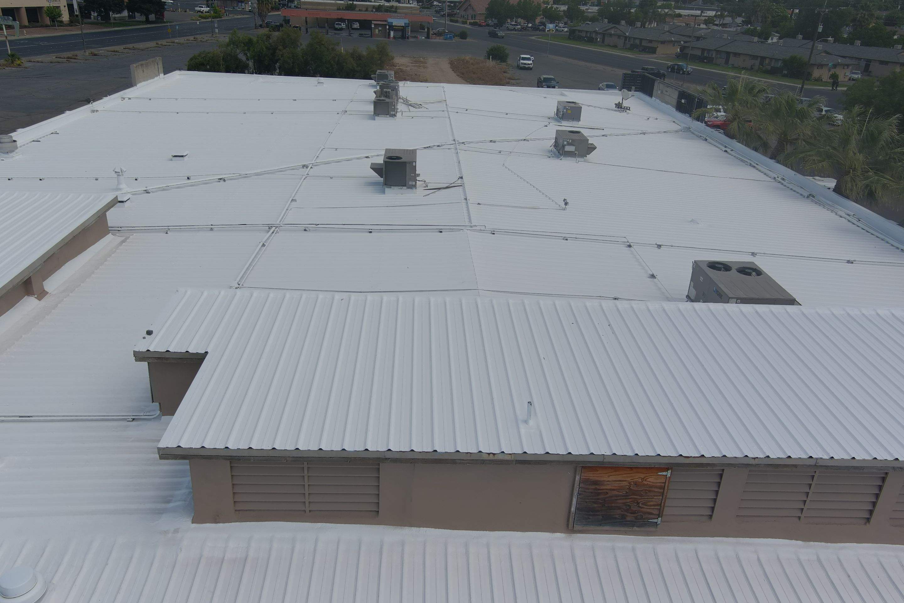 Metal roof restoration on commercial roof using Conklin Benchmark/ PUMA XL acrylic coatings over metal and foam by Straight Edge Roofing Inc