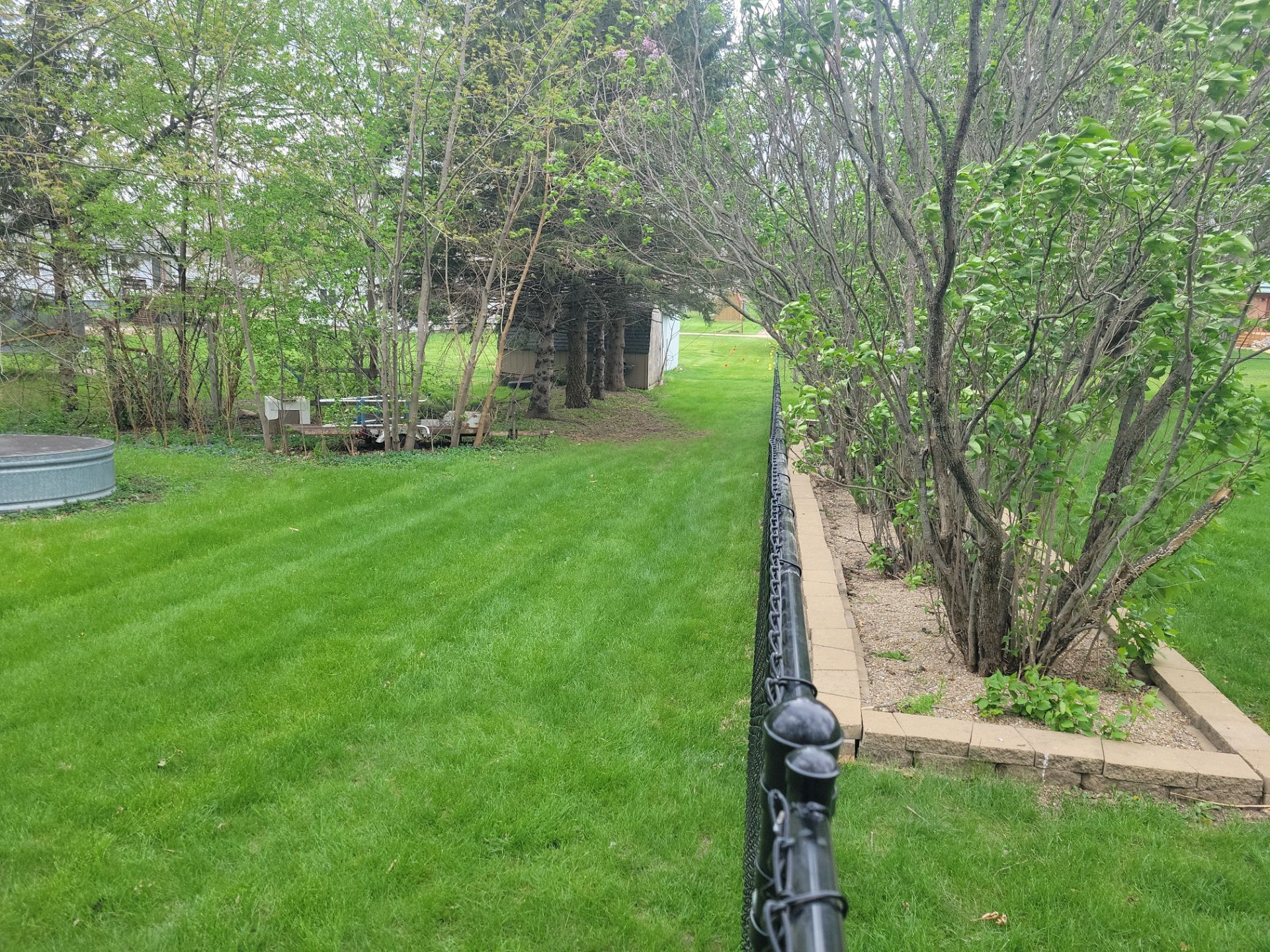 Residential Black Vinyl-Coated Chain Link Perimeter Fence in Garwin by Perfect Picket Fence and Stain
