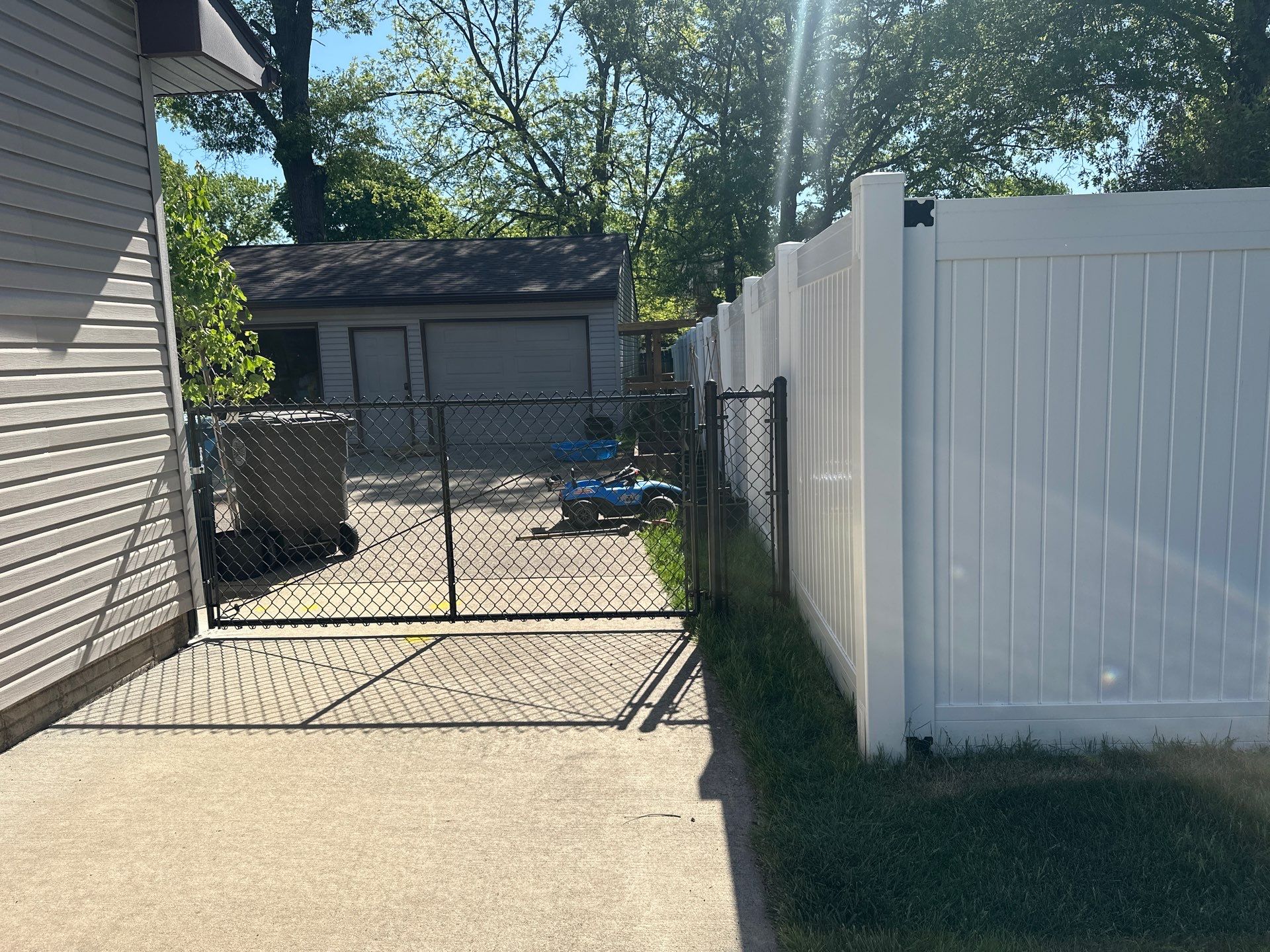Black Chain Link Fence and Driveway Gate Installation in Waterloo by Perfect Picket Fence and Stain