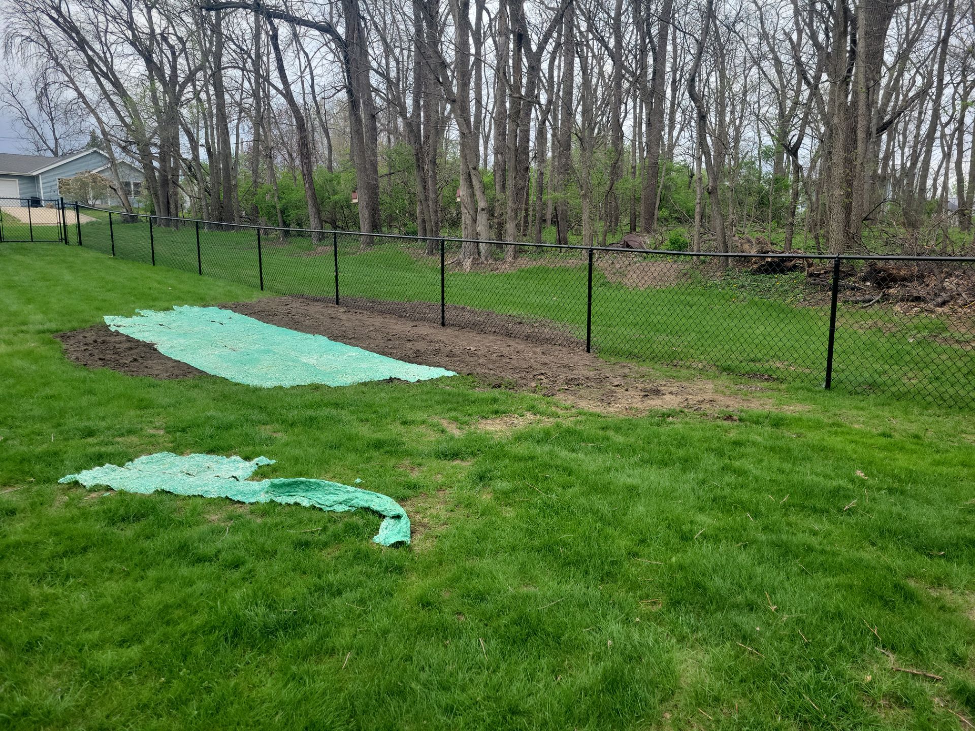 Residential Black Vinyl-Coated Chain Link Perimeter Fence in Garwin by Perfect Picket Fence and Stain