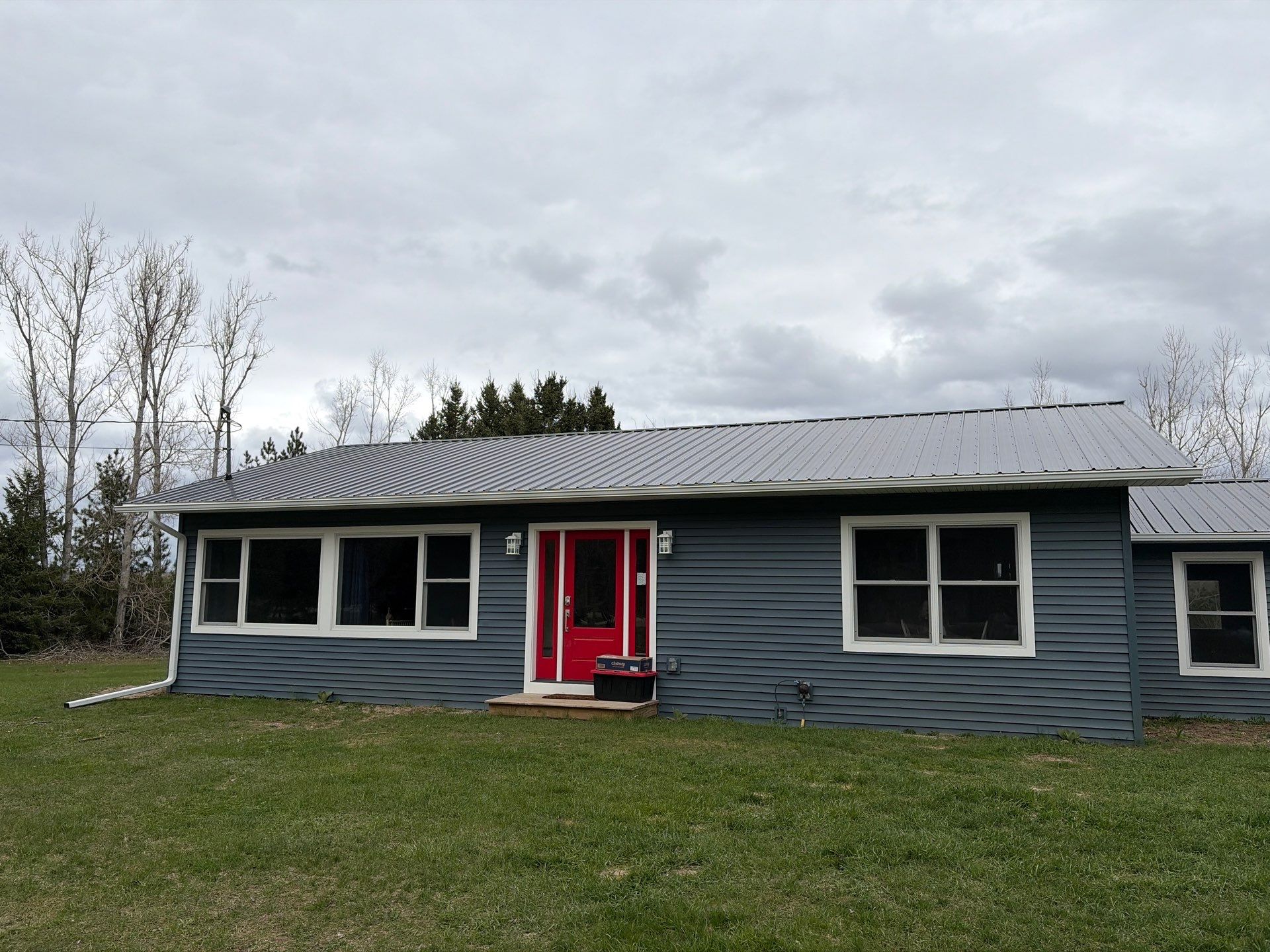 White Gutter and Downspout Installation for Boyne Falls Residential Property by Rainbow Seamless Systems