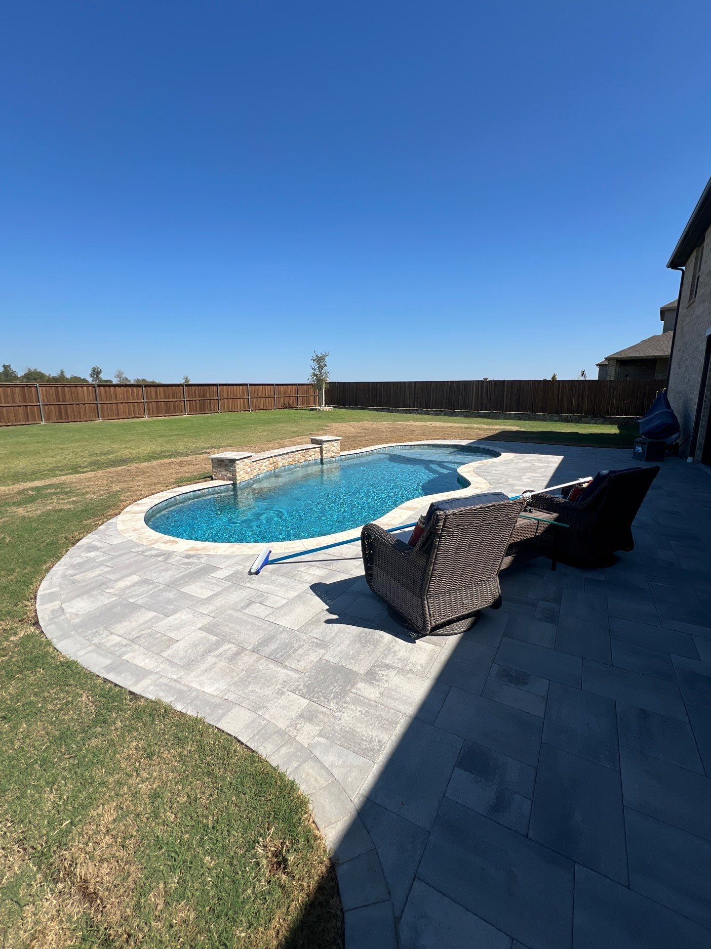 Freeform Pool with Raised Stone Accent Wall by Pinnacle Pools and Spas - DFW