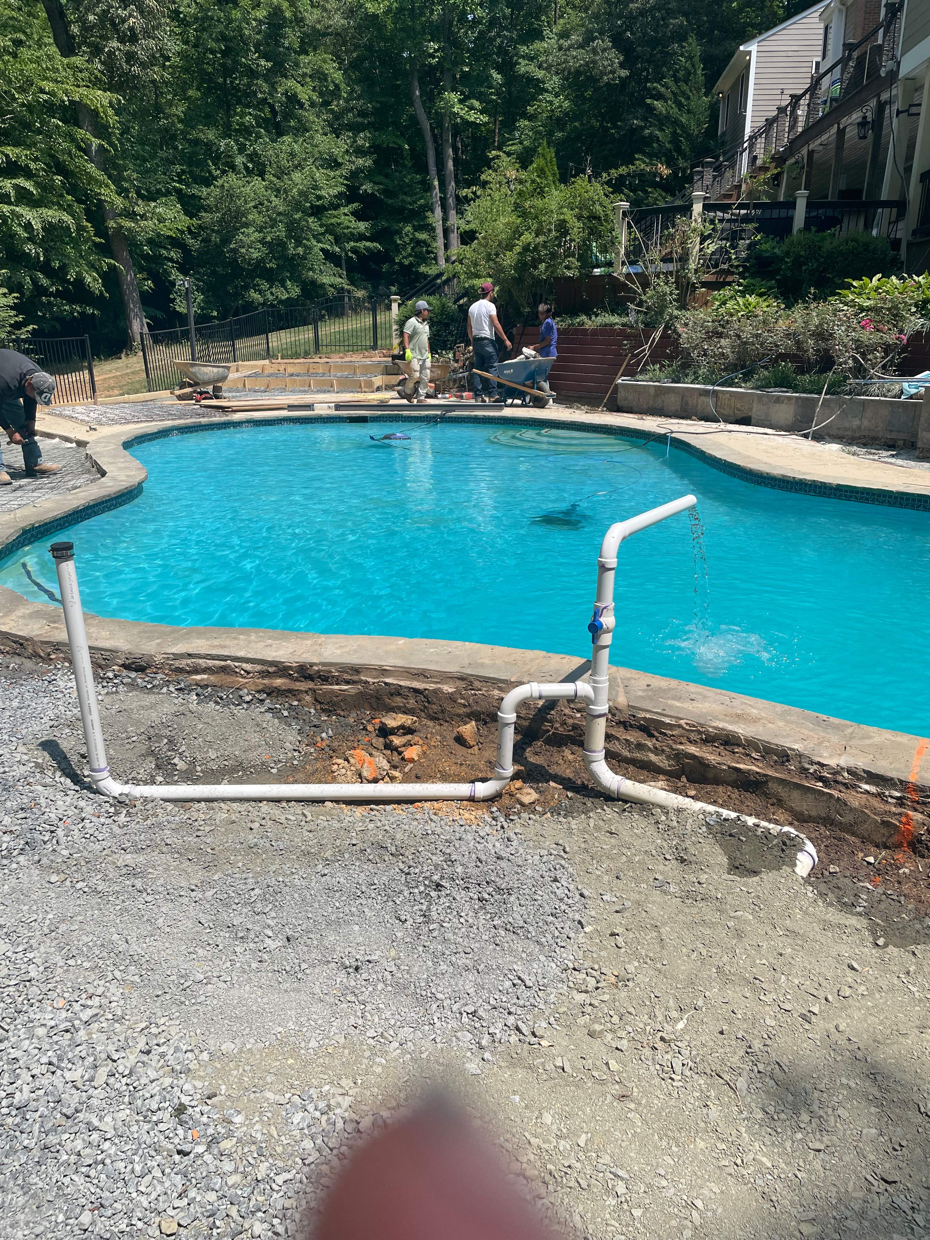 Pool Surround remodel with retaining walls, new waterfall and water slide by Fairfax Contractors, LLC