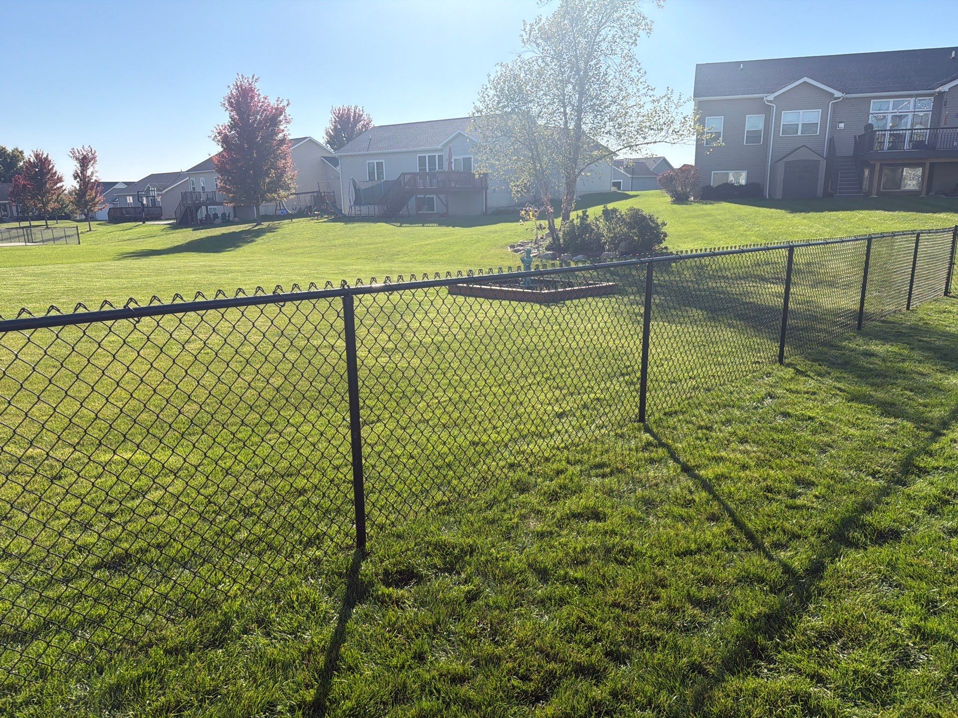 Black Vinyl-Coated Chain Link Fence Installation in Cedar Falls by Perfect Picket Fence and Stain