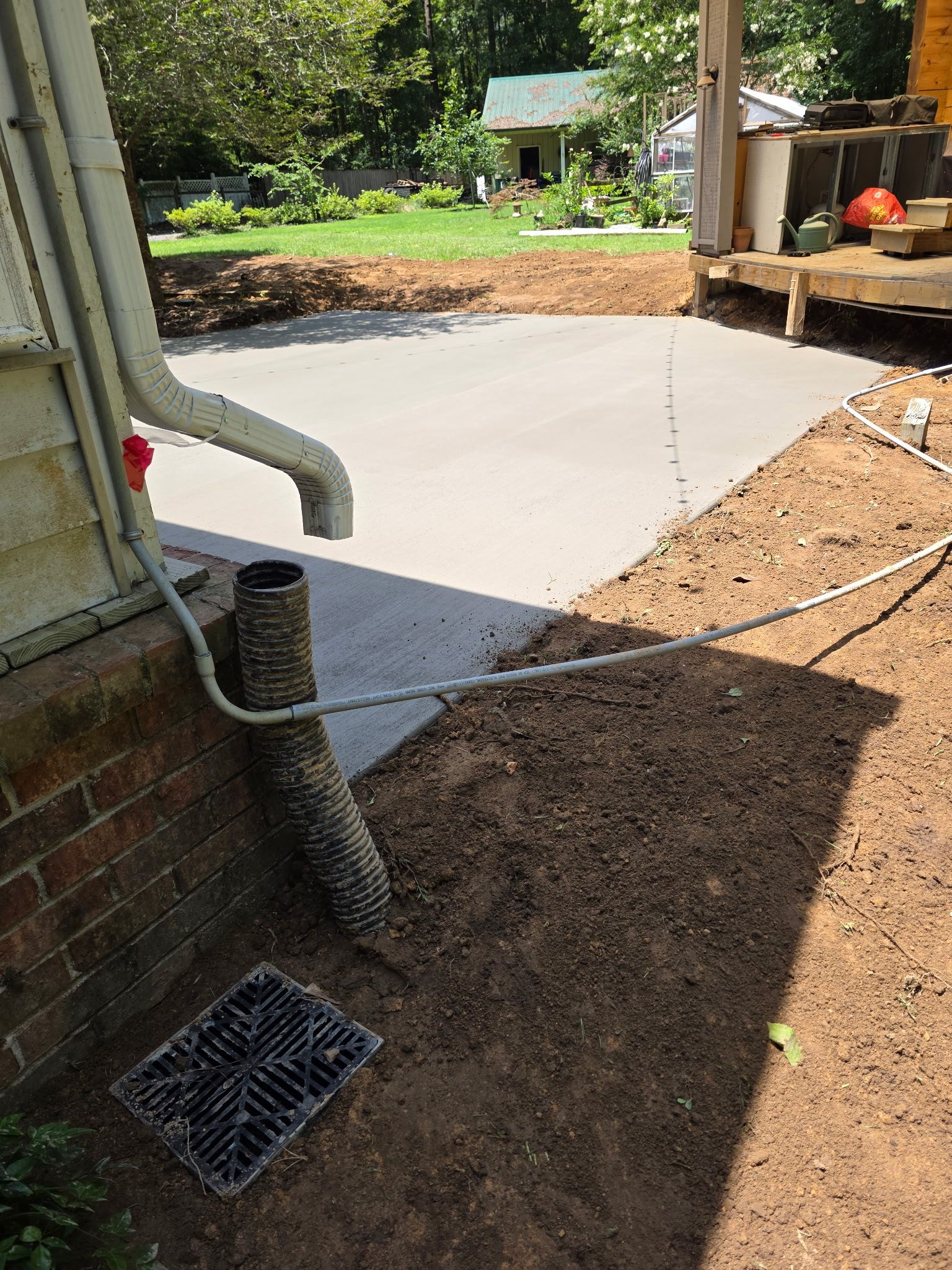 Patio in concrete with drainage improvements by Cornerstone Home Builders, LLC