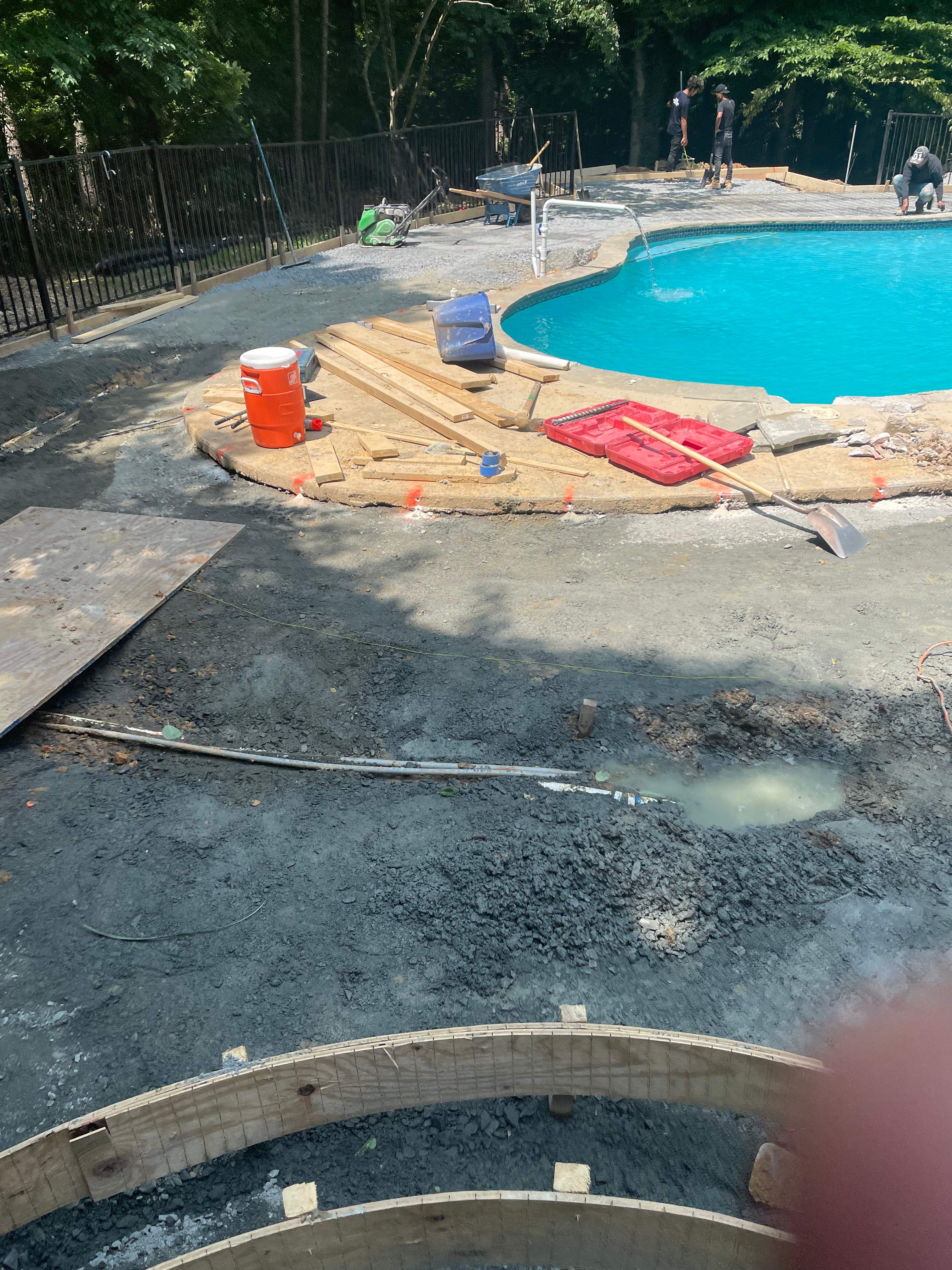 Pool Surround remodel with retaining walls, new waterfall and water slide by Fairfax Contractors, LLC
