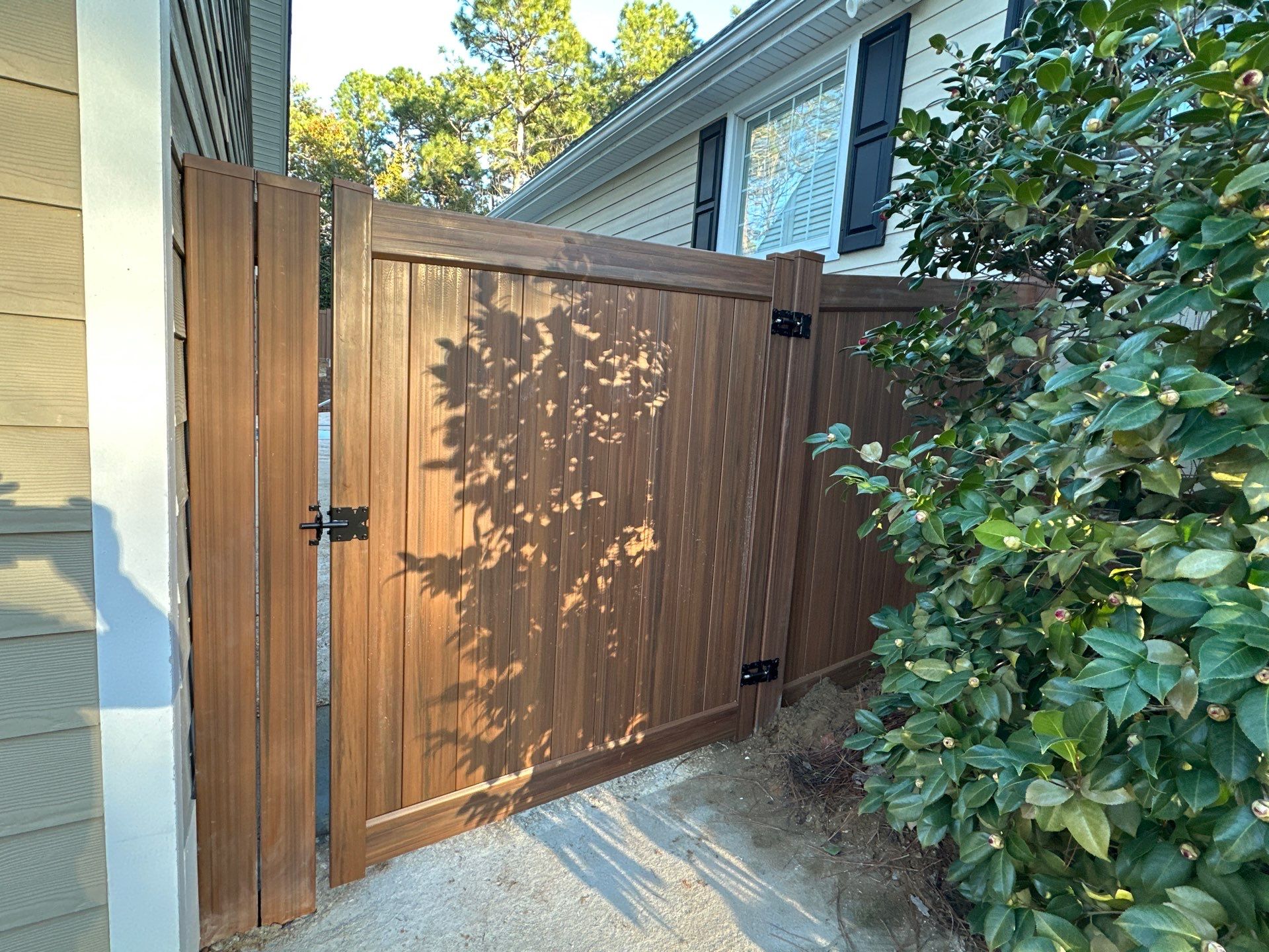 Mocha Walnut Wood-Grain Vinyl Privacy Fence Installation in Southern Pines by Superior Fence and Rail