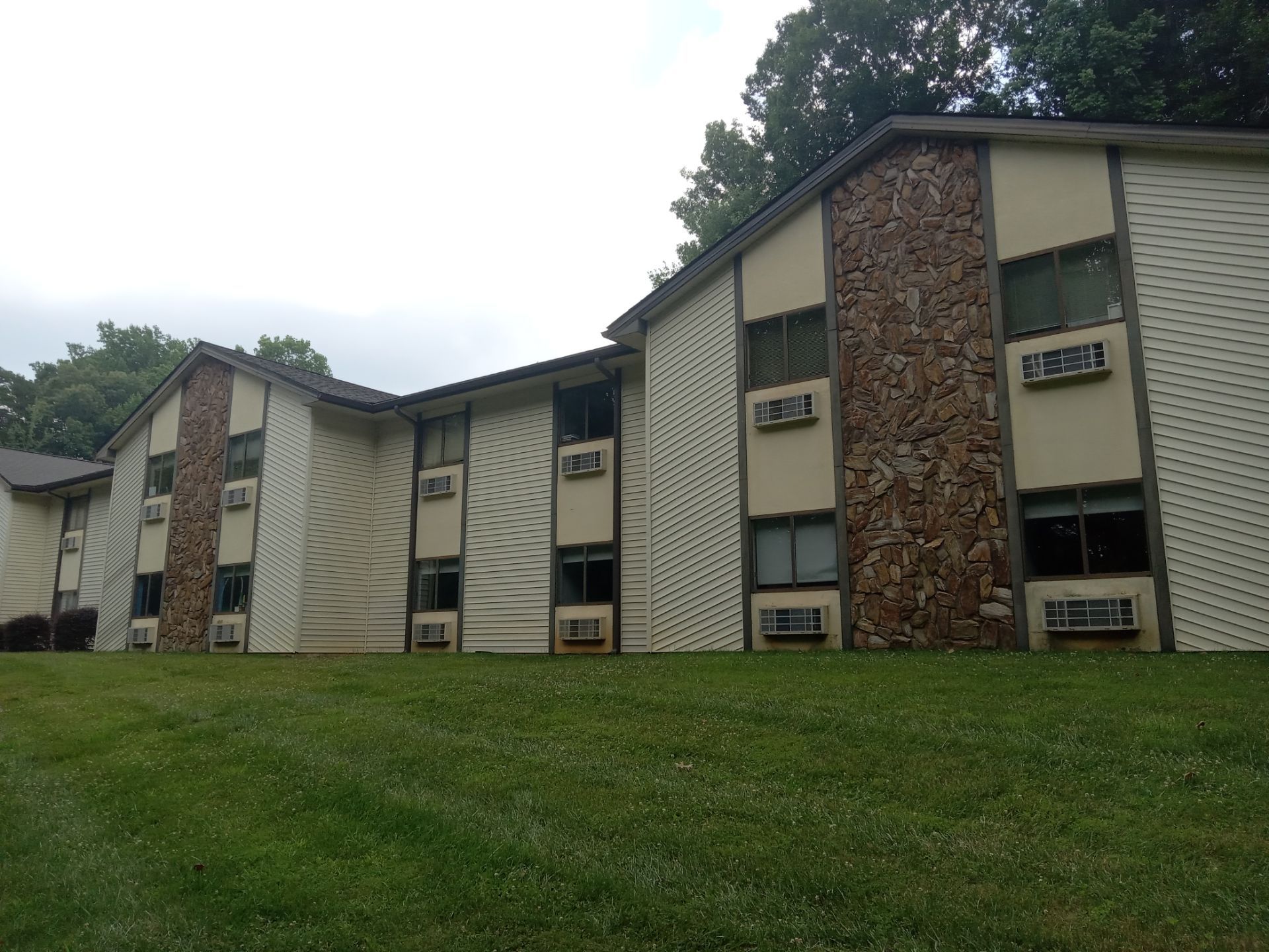 pressure washing exterior siding stone work and windows on apartment building for cleaning and maintenance