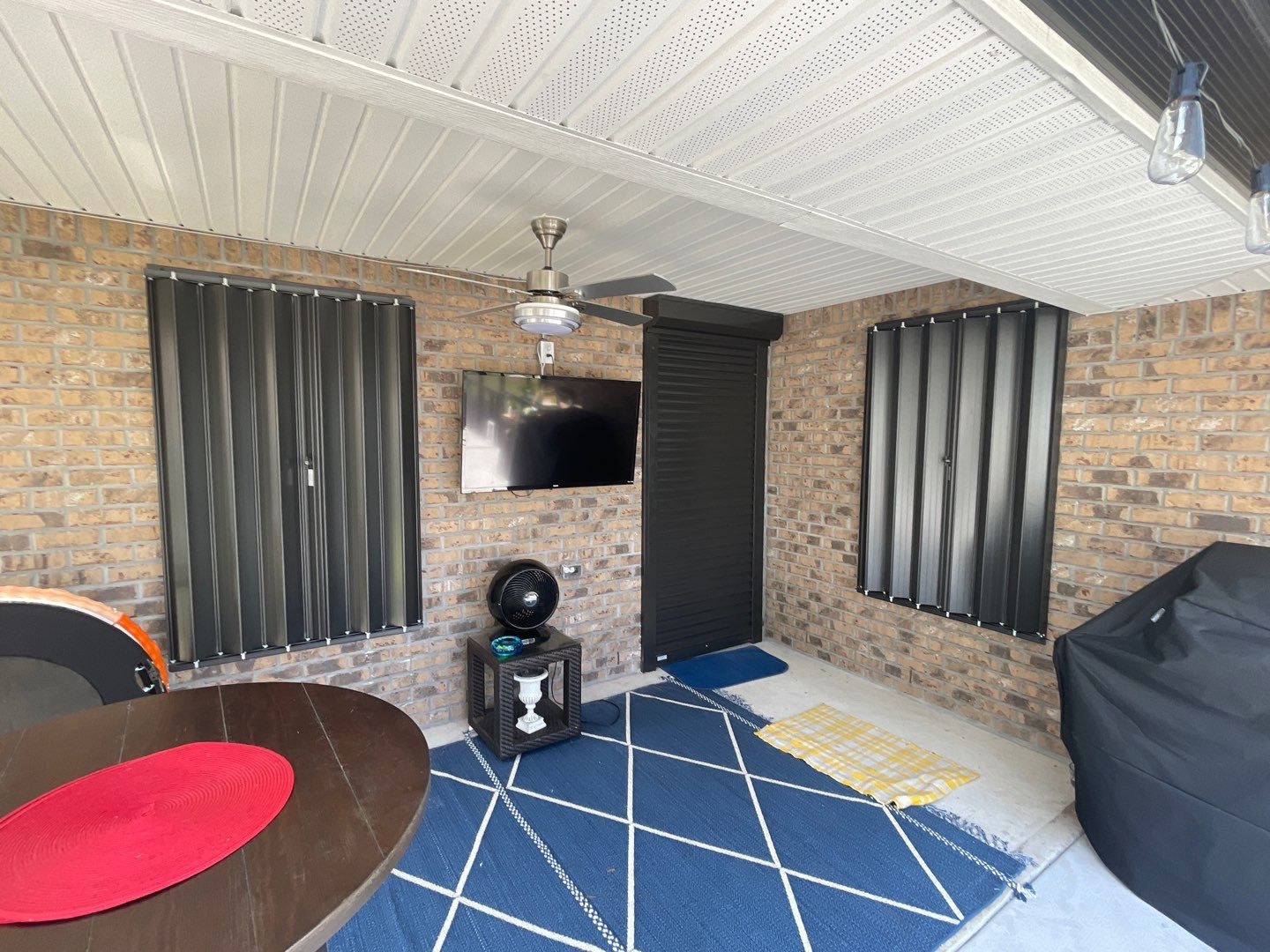 Bronze Accordions on brick home by Smart Guard Shutters