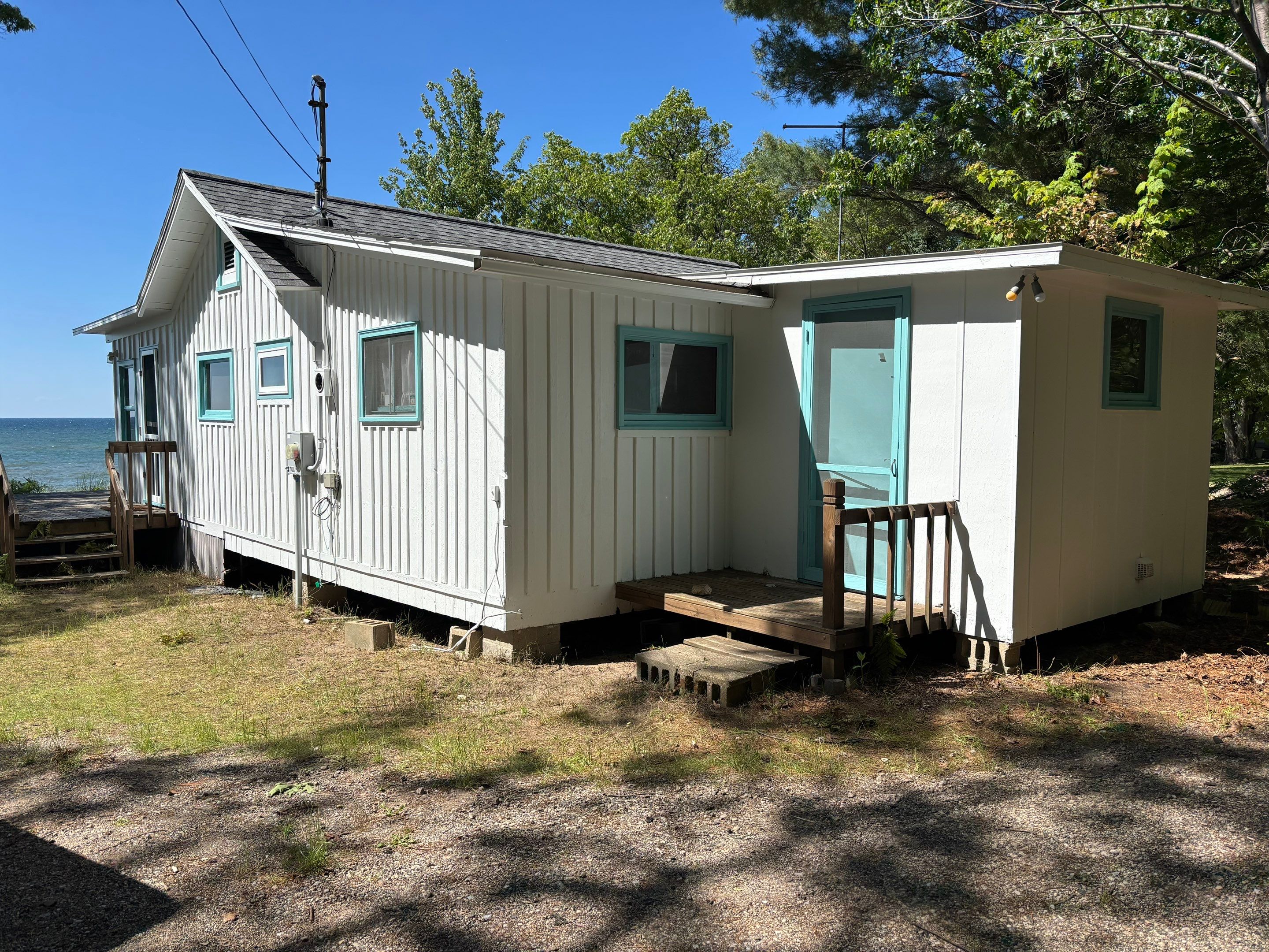 Lakeside Cottage Exterior Painting and Teal Trim Restoration in Mears by Gordon Painting