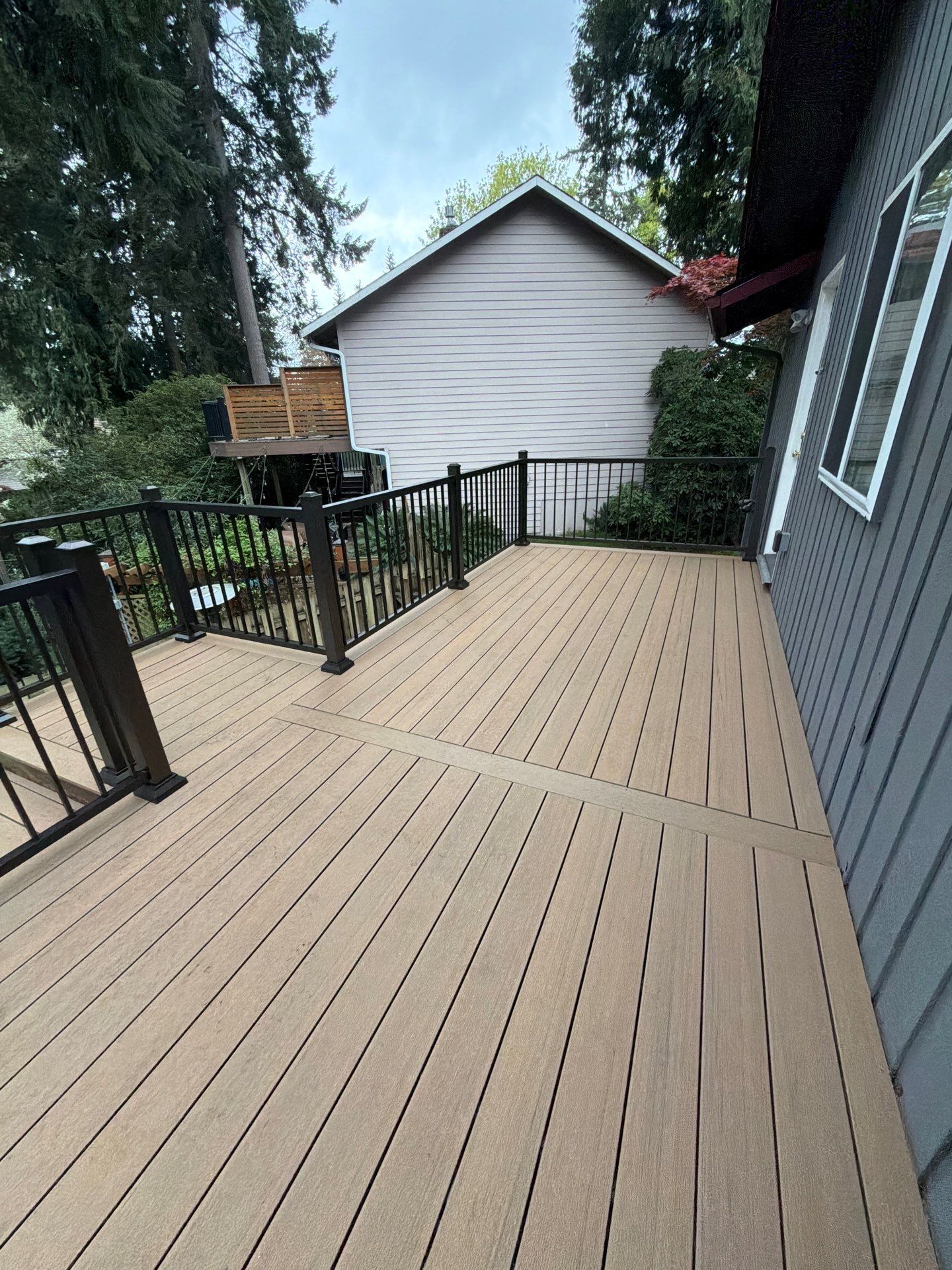 Elevated TimberTech Composite Deck Replacement With Black Metal Railings by Emerald City Energy