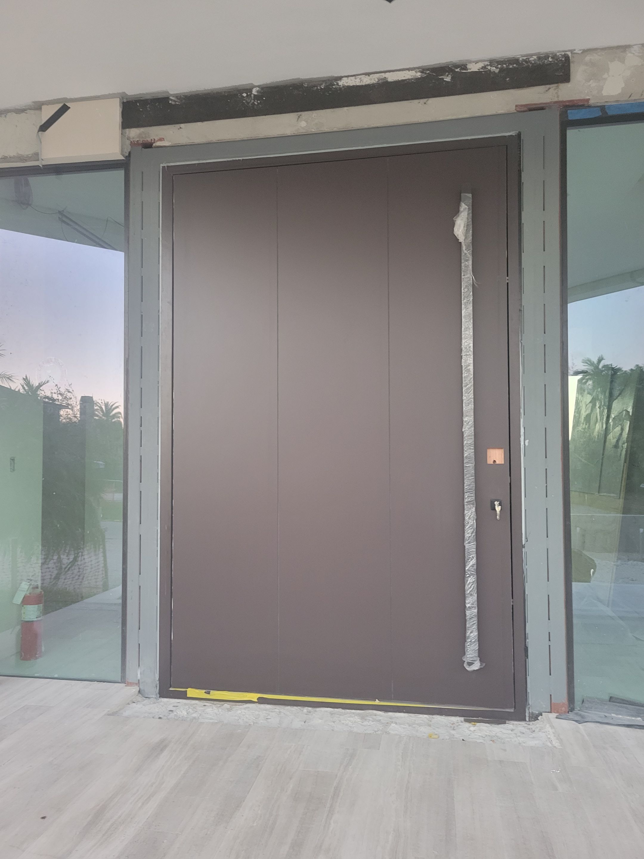 Custom Material Pivot Door installation by Impact Precious Wood Inc.