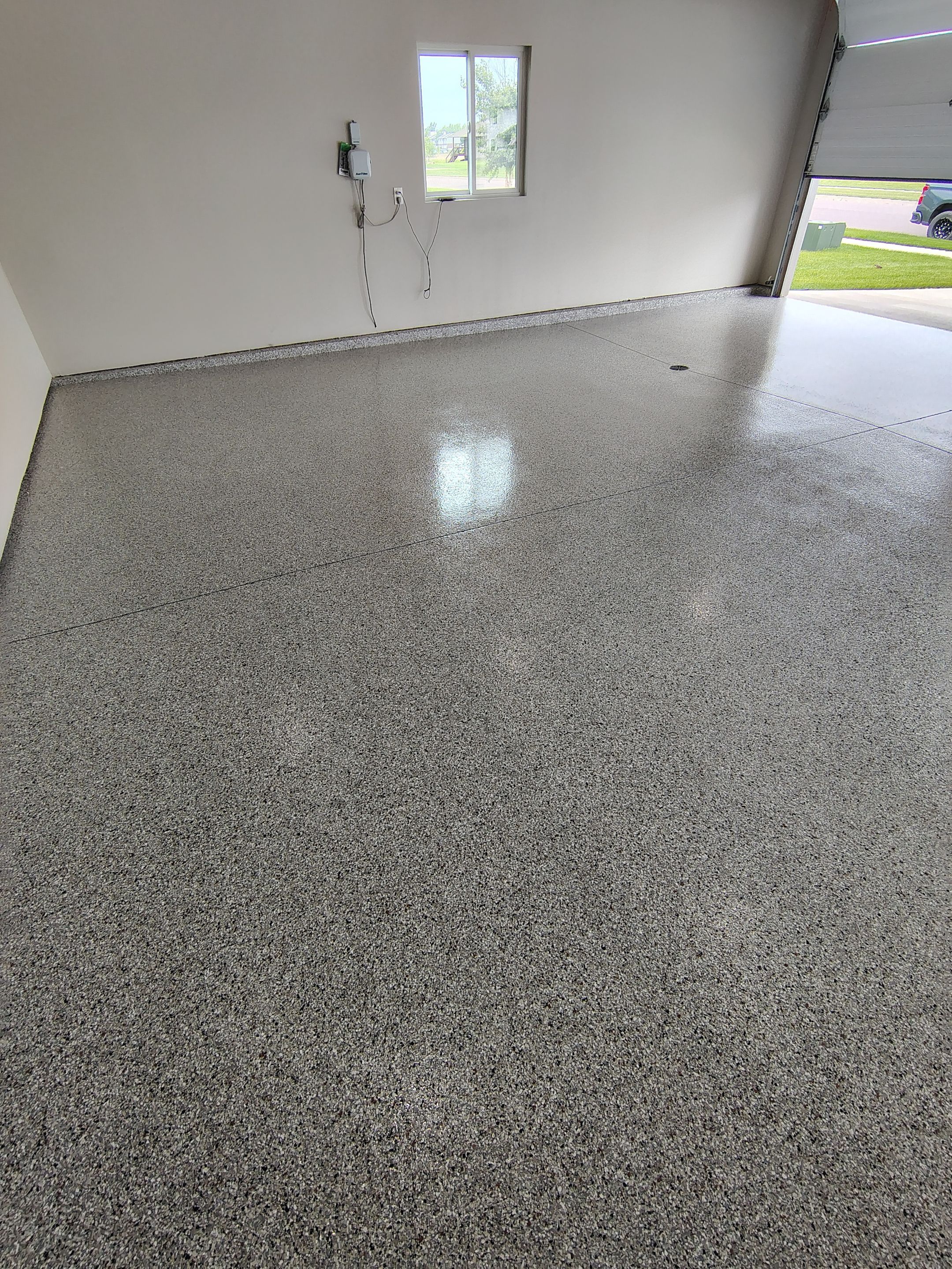 Grey Speckled Epoxy Garage Floor Coating in Sioux Falls by Select Painting, Coatings & Garage Cabinets