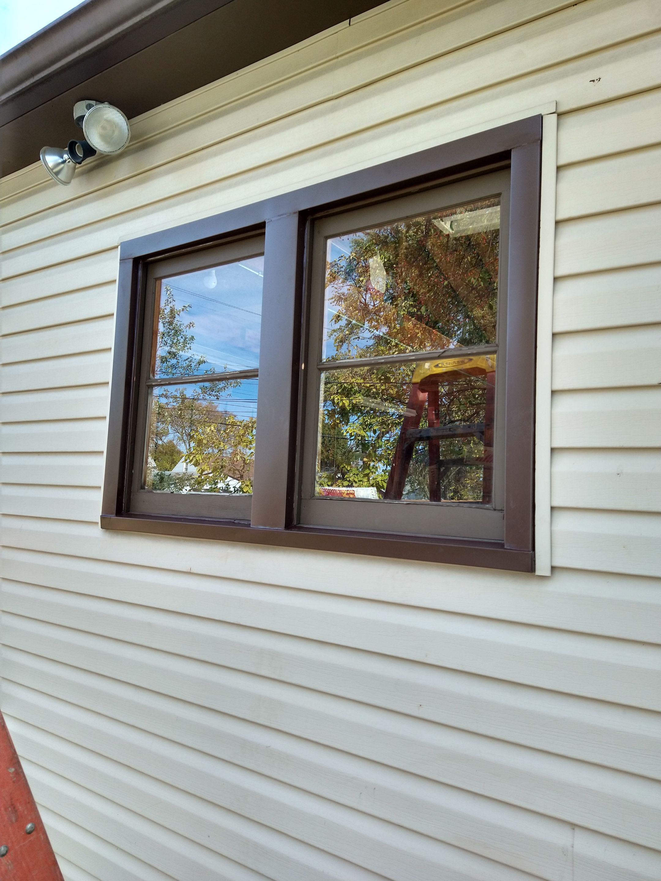 Siding Installation using Norandex woodsman dl-5 white woodgrain vinyl by Absolute Roofing and Construction