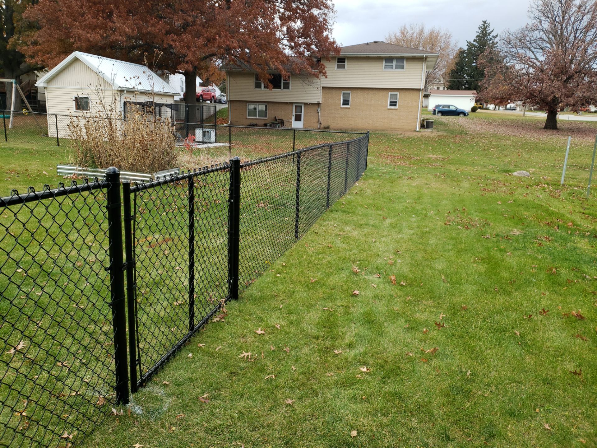Residential Black Vinyl-Coated Chain Link Fence in Grundy Center by Perfect Picket Fence and Stain