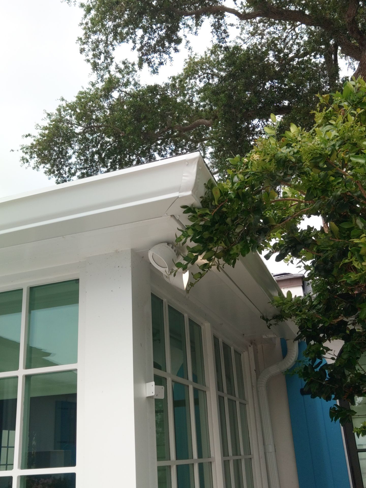 Seamless aluminum gutter installation in Sarasota, FL using 3x4 elbow downspouts combined with round downspouts by Gutter Professors