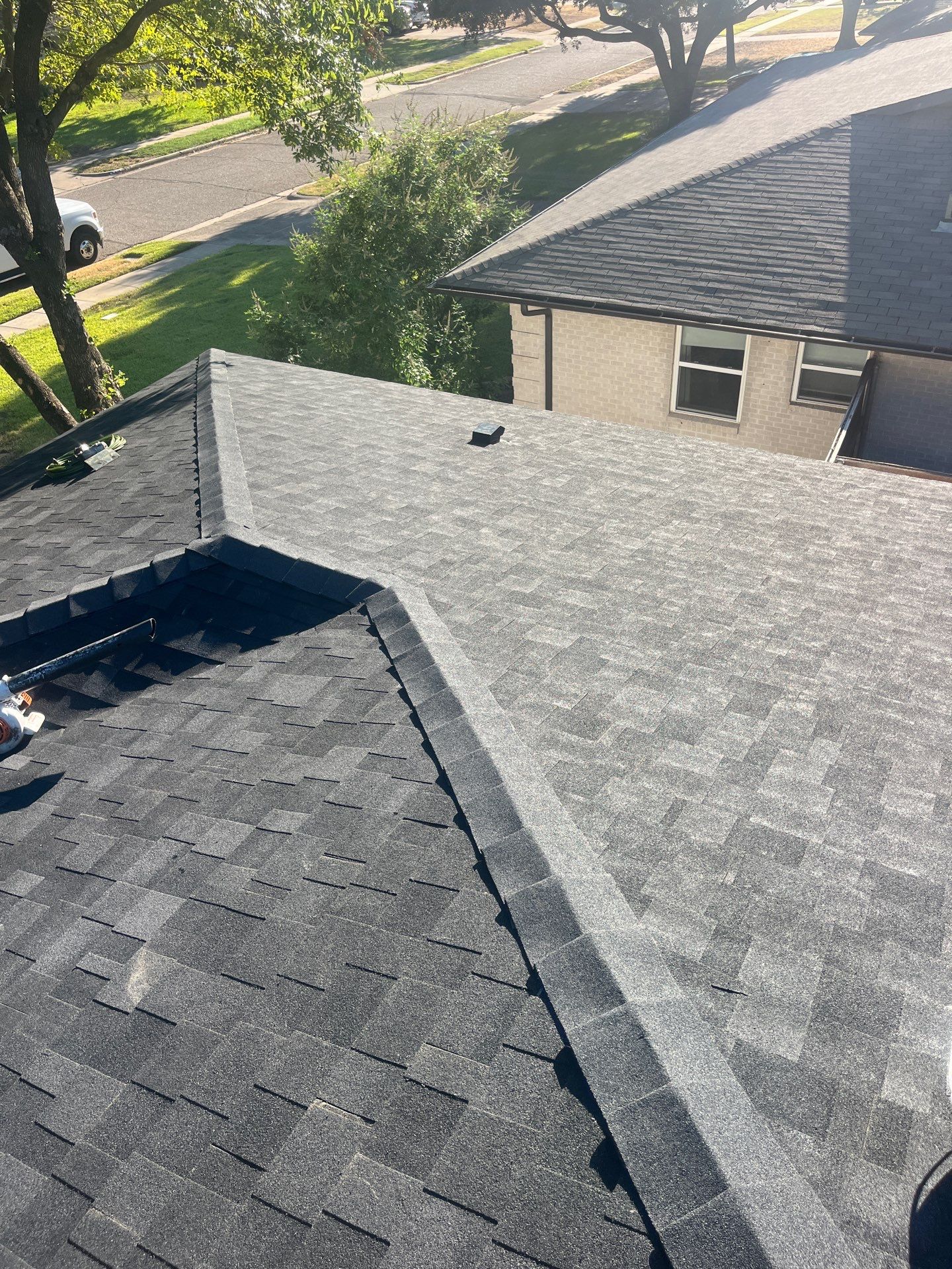 White brick/light gray shutters with IKO Granite Black  by Tejas Roofworks + Restoration