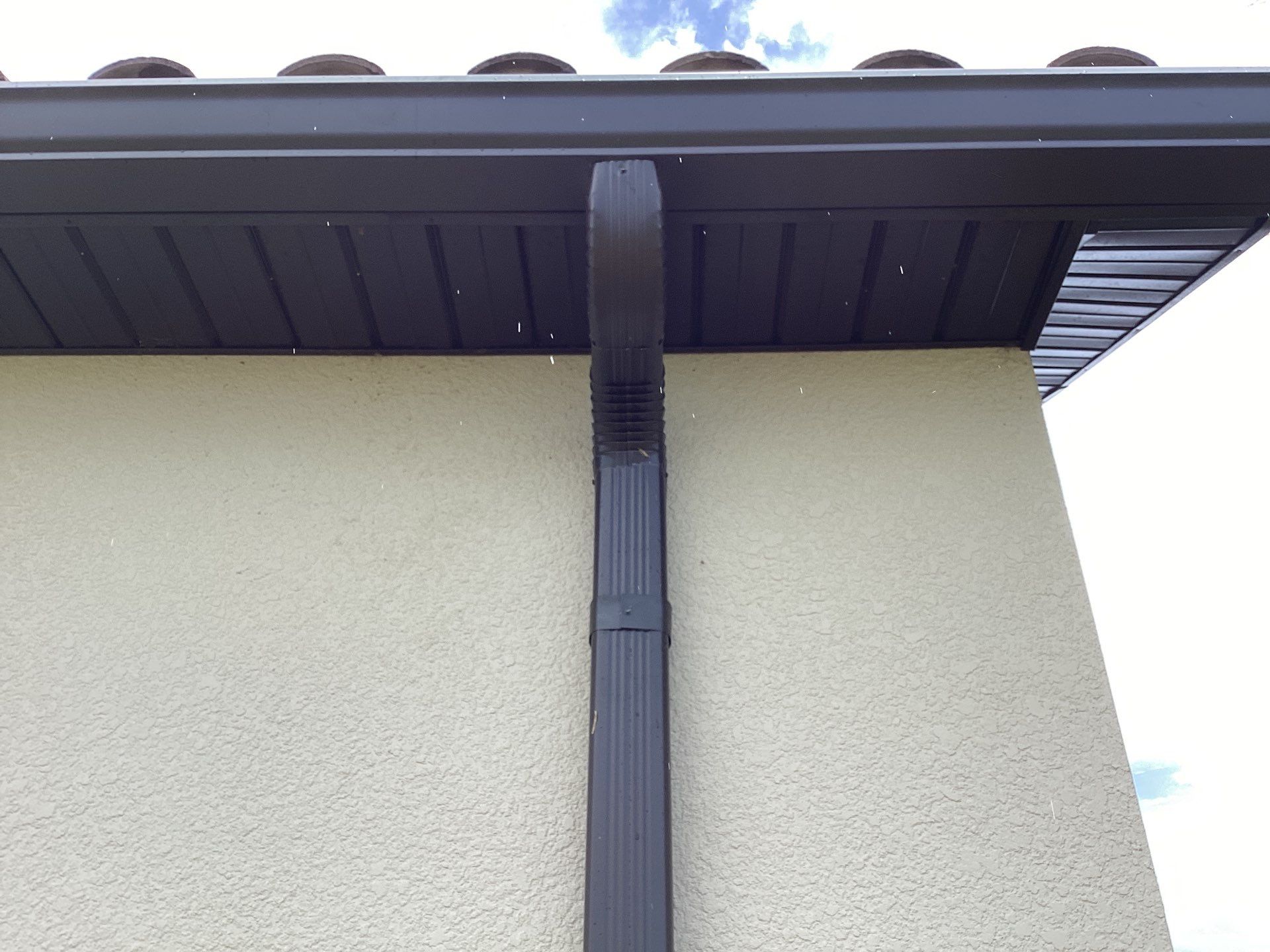 Musket brown seamless gutters with splash guards, new downspouts, and extensions in Bradenton, FL by Gutter Professors