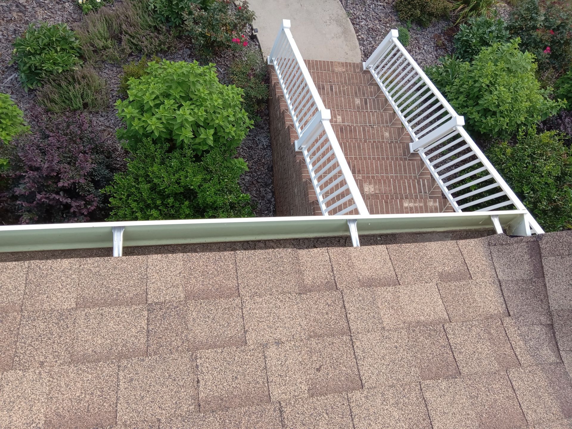 pressure washing of brick steps white railing and possibly the roof shingles cleaning exterior surfaces removing dirt grime buildup